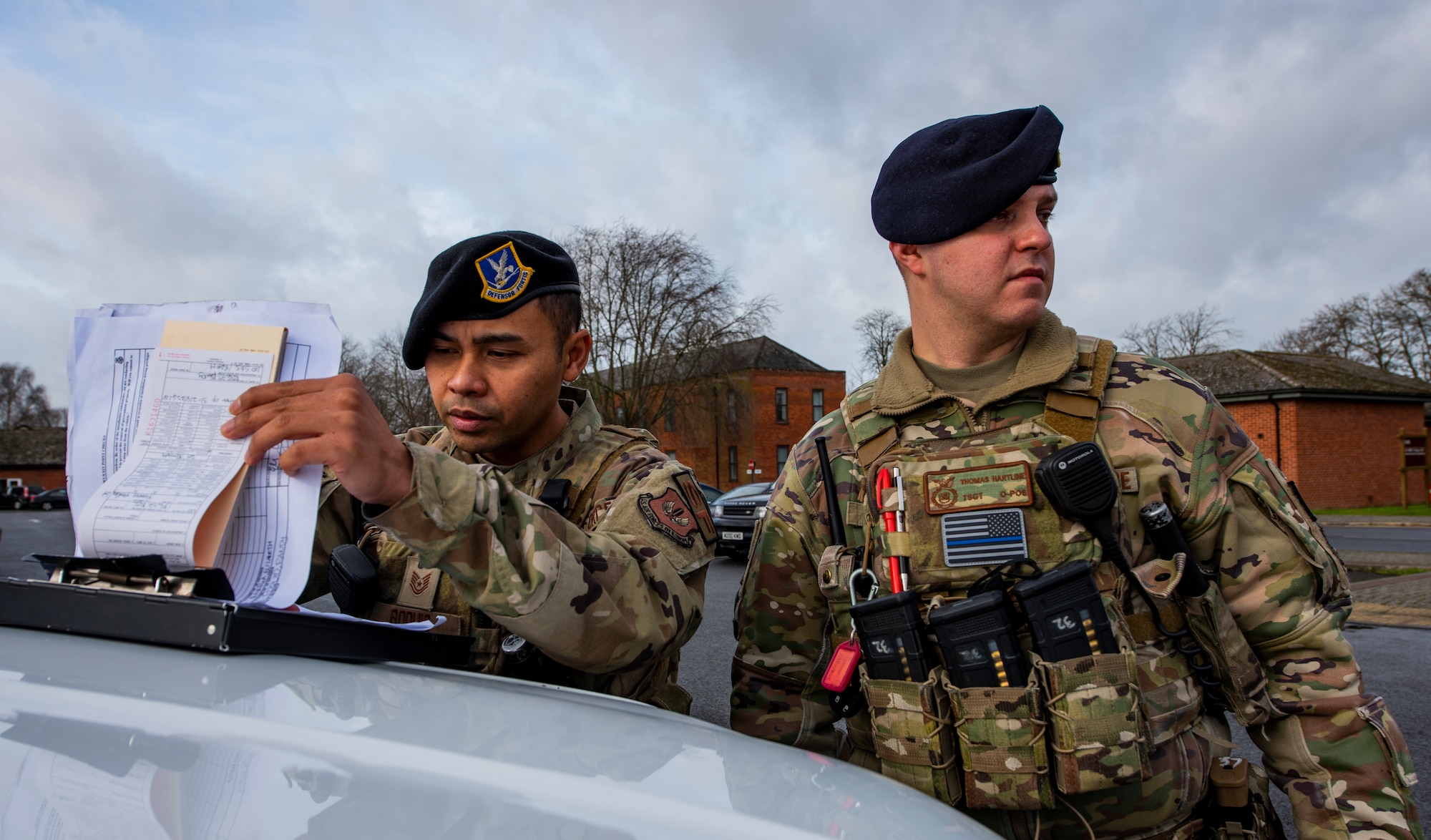 U.S. Air Force Tech. Sgt. Randy Roquid, left, and Tech. Sgt. Thomas Hartline, right, 100th Security Forces Squadron flight sergeants, prepare to issue parking violations on Royal Air Force Mildenhall, England, Feb. 16, 2022. By strictly enforcing the use of legal parking spaces, members of the 100th SFS ensure emergency vehicles are able get where they need to be in a moment’s notice. (U.S. Air Force photo by Senior Airman Kevin Long)