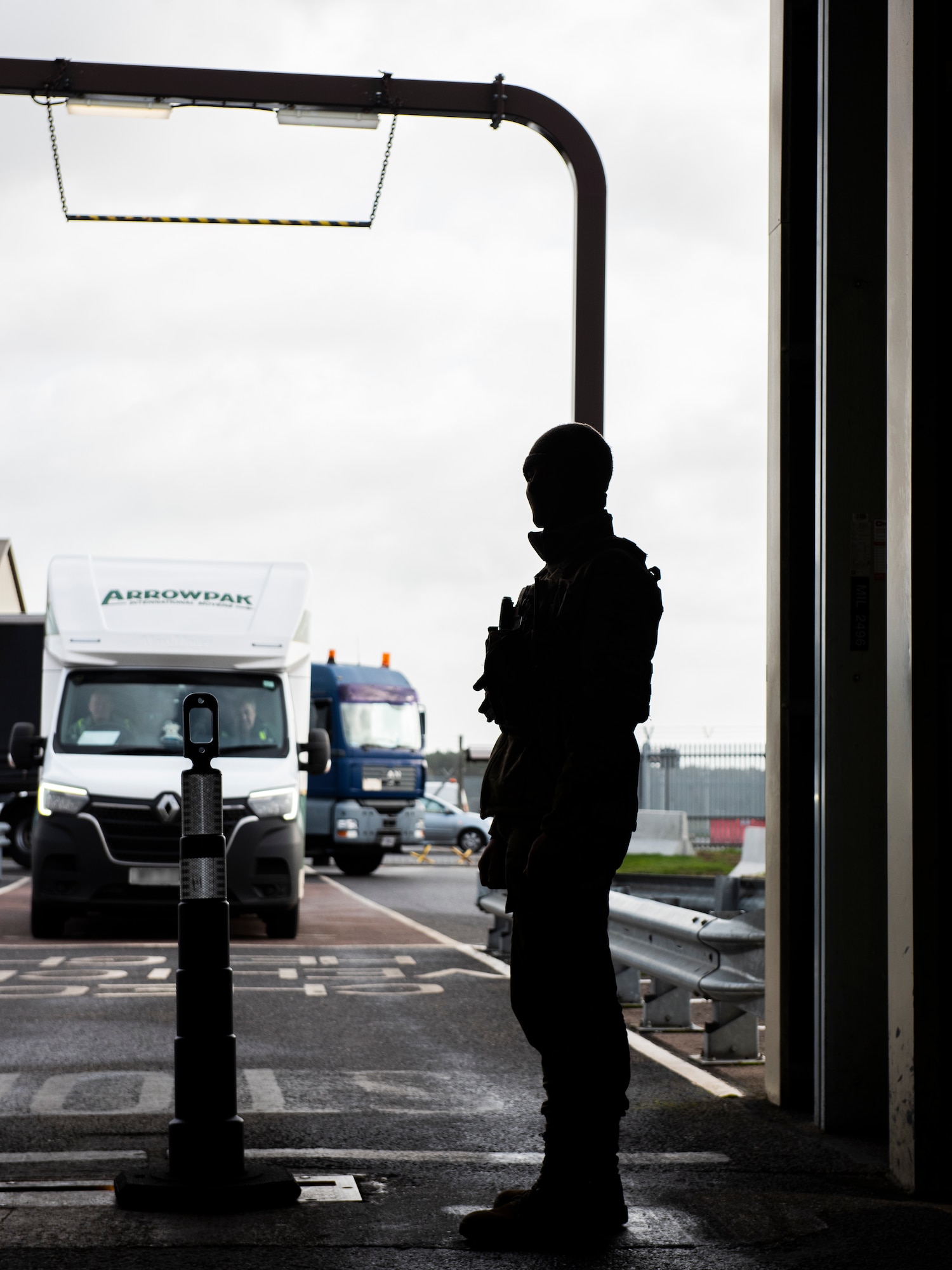 Senior Airman Cade Zellman, 100th Security Forces Squadron response force leader, controls traffic entering the vehicle inspection area on Royal Air Force Mildenhall, England, Feb. 16, 2022. This crucial step our Defenders take ensures the installation and Team Mildenhall stay safe and secure for the mission to continue. (U.S. Air Force photo by Senior Airman Kevin Long)