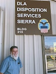 A man stands in front of a sign.