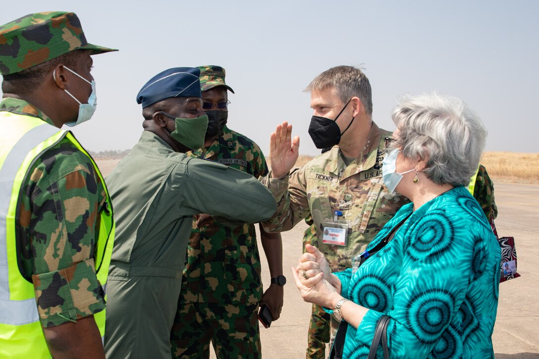 U.S. Army Corps of Engineers North Atlantic Division Commander Brig. Gen. Thomas Tickner greets a member of the Nigerian Air Force by bumping elbows while visiting ongoing construction at Kainji Air Force Base in Nigeria with U.S. Ambassador Mary Beth Leonard February 15, 2022. The officials participated in a groundbreaking ceremony highlighting the ongoing construction of support facilities for recently delivered A-29 Super Tucano aircraft. The construction is a part of the historic $500 million U.S. foreign military sale to Nigeria, which also includes the delivery of the 12 A-29 Super Tucano aircraft, munitions, and training. (Photo Courtesy of the U.S. Embassy in Nigeria)