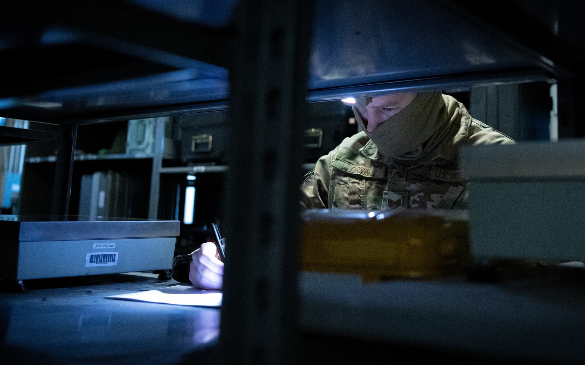 A U.S. Airman checks inventory during a simulated power outage.
