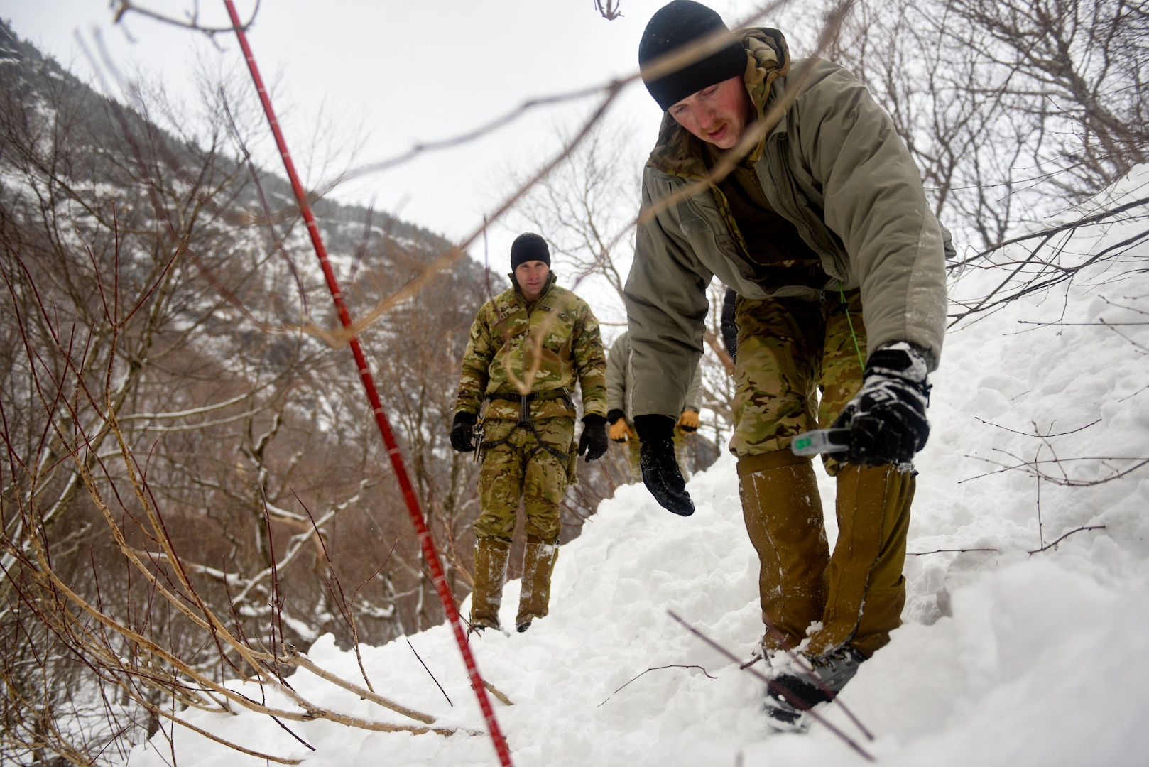 Sgt. 1st Class Nick Ash, an instructor at the U.S. Army Mountain Warfare School, observes a student using a locator beacon to find a simulated casualty during avalanche rescue training as part of the school’s Advanced Military Mountaineer Course Jan. 25, 2022. The AMWS is a U.S. Army Training and Doctrine Command school operated by the Vermont Army National Guard at Camp Ethan Allen Training Site, Vermont.