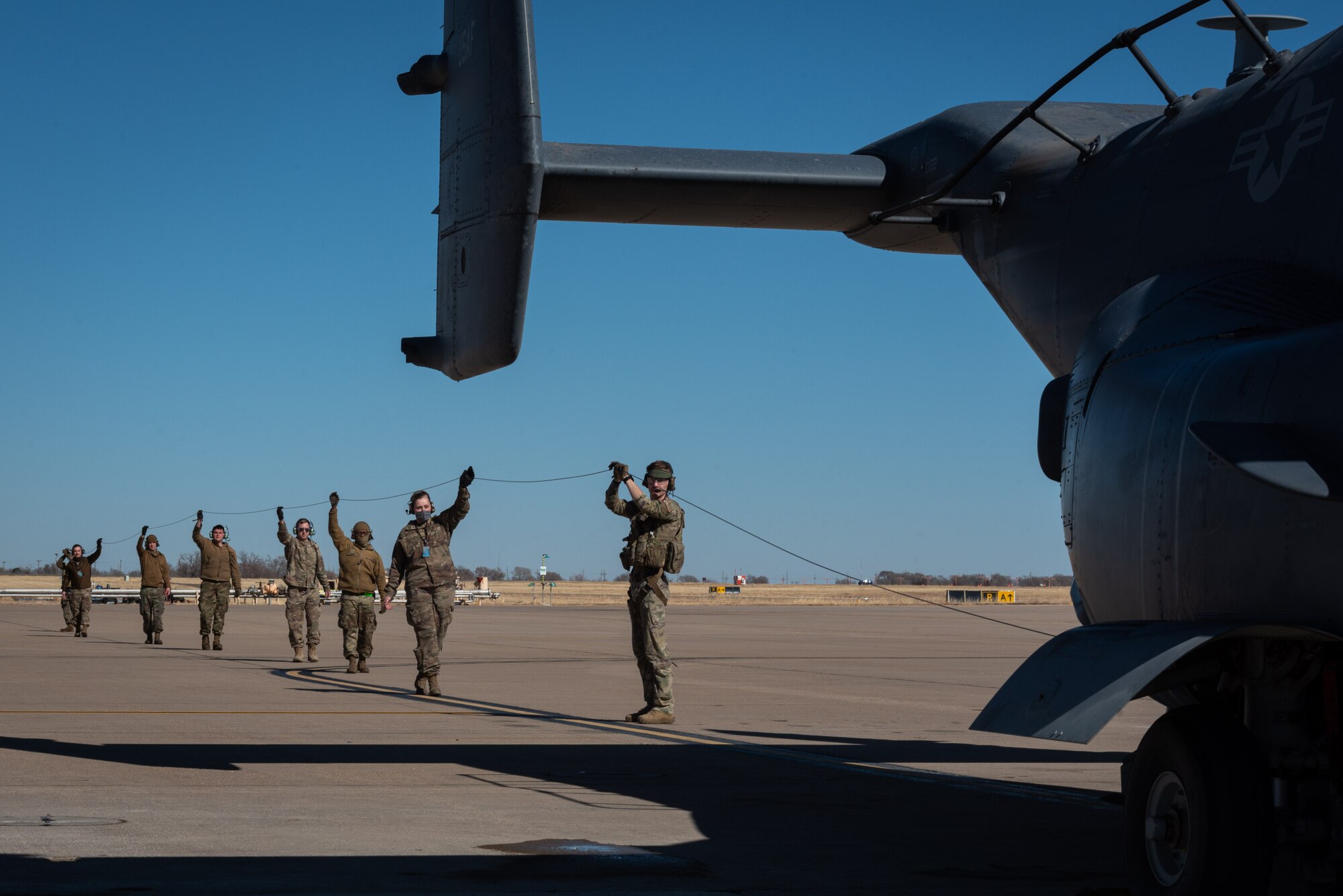 U.S. Air Force Airmen test the hoist line on a CV-22 Osprey tiltrotor aircraft prior to flight.