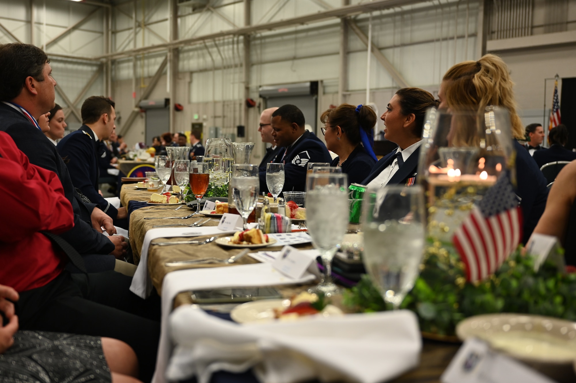 Attendees from the 14th Flying Training Wing listen to the Master of Ceremony, during the Annual Awards and Dining Out Ceremony, Feburary 12, 2022, on Columbus Air Force Base, Miss. Annual Awards Ceremonies are used as a way to show appreciation to base personnel for their hard work and dedication toward the mission, throughout the year. (U.S. Air Force Photo by Second Lieutenant Peyton Craven)