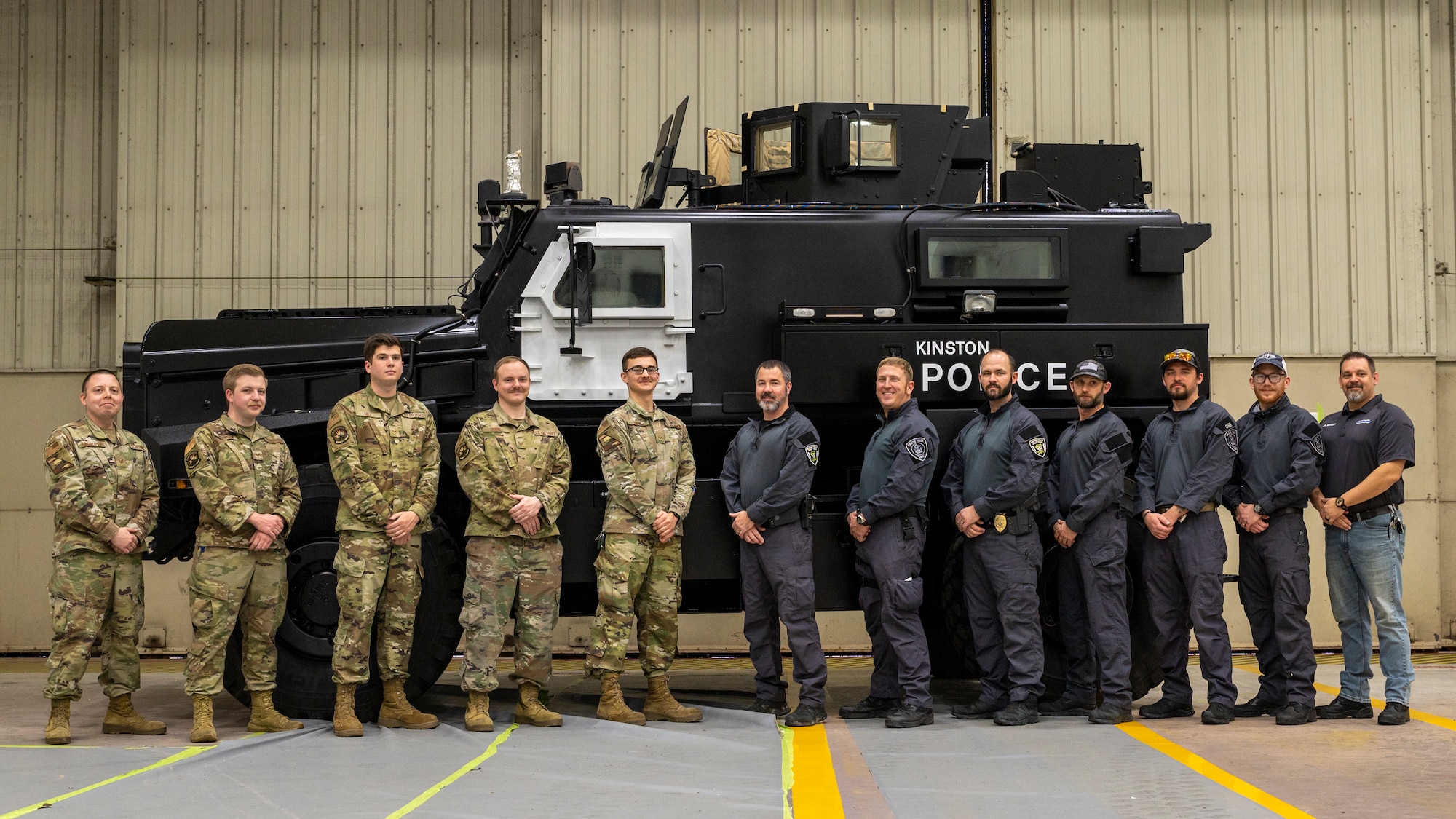 Airmen from the 4th Equipment Maintenance Squadron aircraft structural maintenance section and police officers from the Kinston Police Department, Kinston, North Carolina, pose for a photo at Seymour Johnson Air Force Base, North Carolina, Feb. 4, 2022.