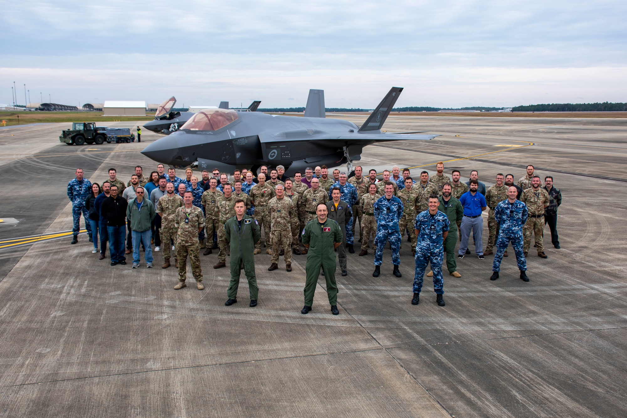 Members of the Royal Australian Air Force and Australia-Canada-United Kingdom Reprogramming Laboratory stand in front of an F-35A Lightning II on Nov. 23, 2021, at Eglin Air Force Base, Fla. This is the second year No 77 Squadron has participated in Exercise Lightning Spear, a live-fire missile event supported by the 53rd Wing that evaluates the entire unit on their ability to support the AIM-120D Advanced Medium Range Air-to-Air Missile combat capability of their F-35s. The RAAF works alongside ACURL to reprogram the mission data collected during ELS. (U.S. Air Force photo by 1st Lt. Lindsey Heflin)
