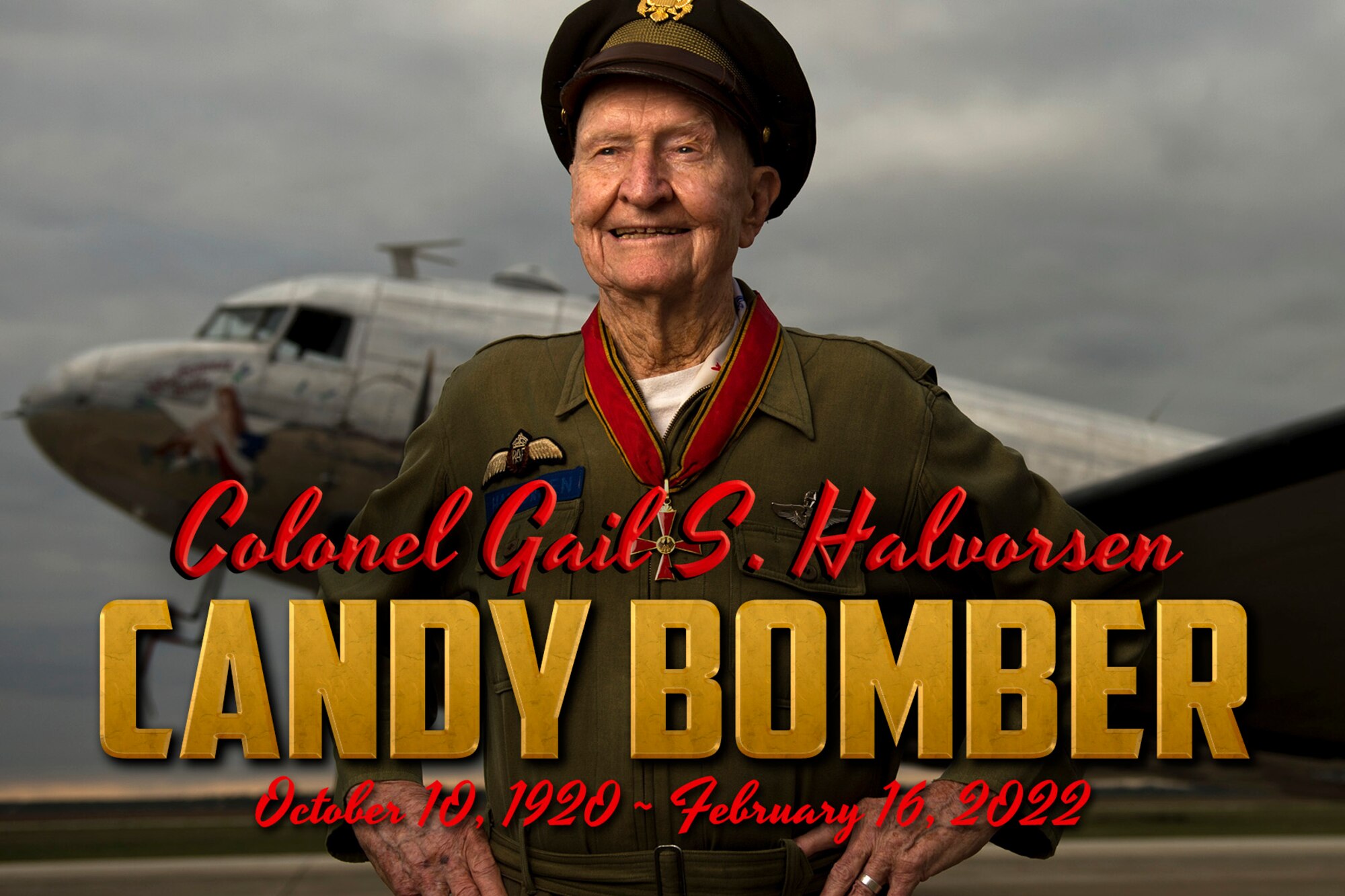 The Candy Bomber poses in front of an aircraft while the words Col. Gail S. Halovrsen, Candy Bomber, October 10, 1920-February 16, 2022, appear at the bottom of the image.