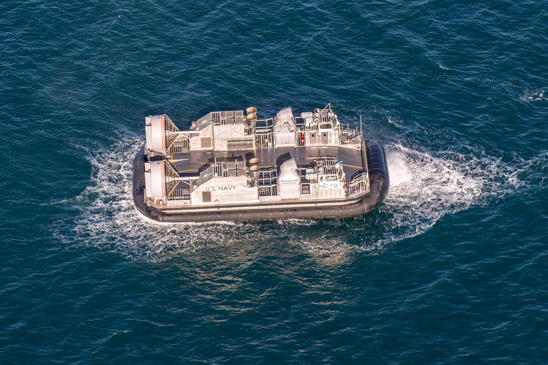 A small rubber boat transits a body of water.