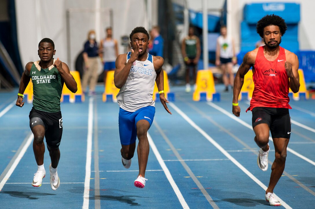 A cadet runs in a track meet against two other competitors.