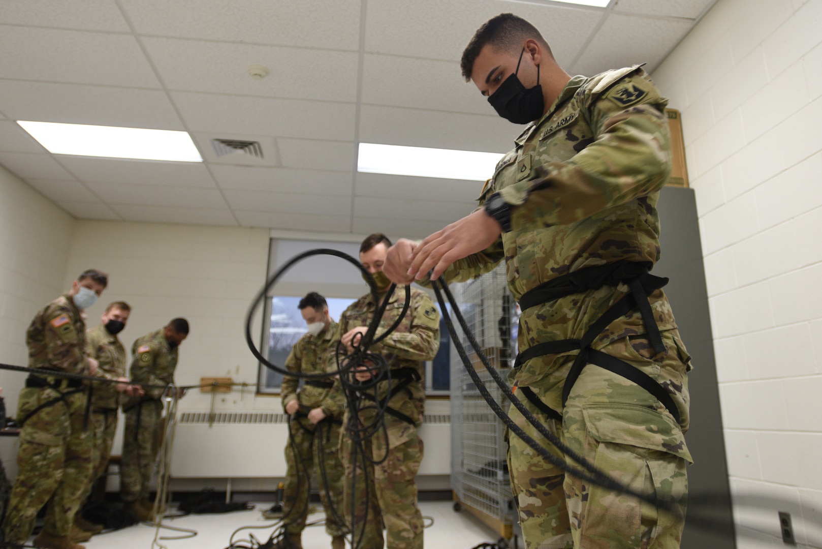 Pfc. Cassio Alvarenga, a student at the U.S. Army Mountain Warfare School’s Basic Military Mountaineer Course, practices knot-tying Jan. 20, 2022, the night before he and other students are tested on 27 different knots. The AMWS is a U.S. Army Training and Doctrine Command school operated by the Vermont Army National Guard at Camp Ethan Allen Training Site, Vermont.