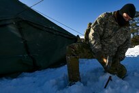 A student at the U.S. Army Mountain Warfare School’s Basic Military Mountaineer Course sets up a tent in preparation to learn to sleep in subzero temperatures Jan. 20, 2022. The AMWS is a U.S. Army Training and Doctrine Command school operated by the Vermont Army National Guard at Camp Ethan Allen Training Site, Vermont.