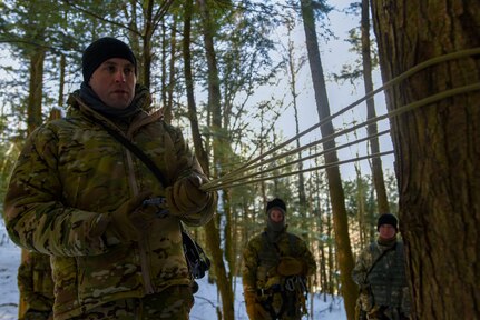 Staff Sgt. John Hampson, an instructor at the U.S. Army Mountain Warfare School, demonstrates a casualty evacuation system to students at the school’s Basic Military Mountaineer Course at Camp Ethan Allen Training Site, Vermont, Jan. 22, 2022. U.S. and foreign service members learn basic, advanced and specialty mountain warfare skills at the school.