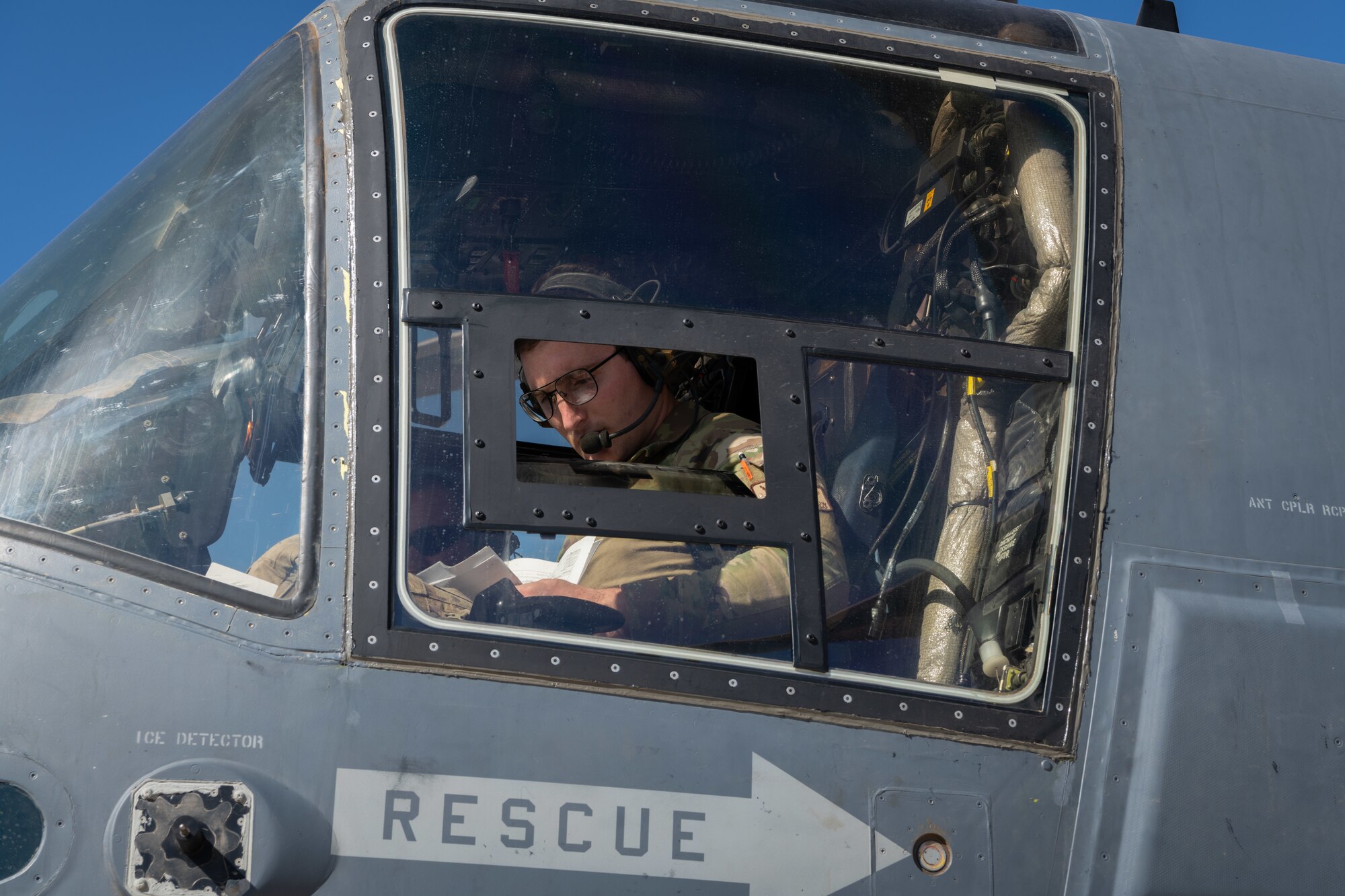 A U.S. Airman goes through his preflight checklist aboard a CV-22 tiltrotor aircraft.