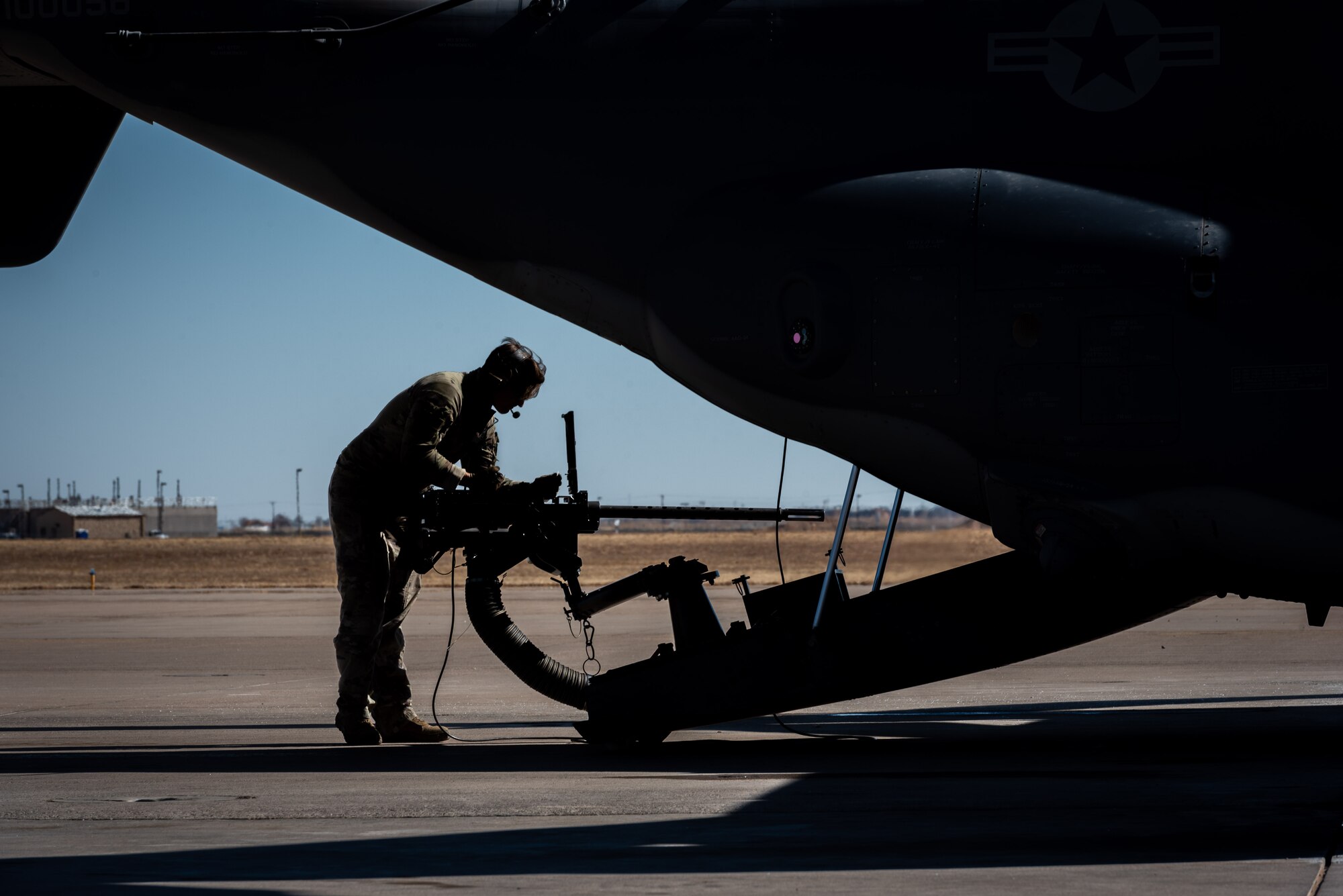 A U.S. Airman checks a weapon on the CV-22 Osprey tiltrotor aircraft prior to flight.