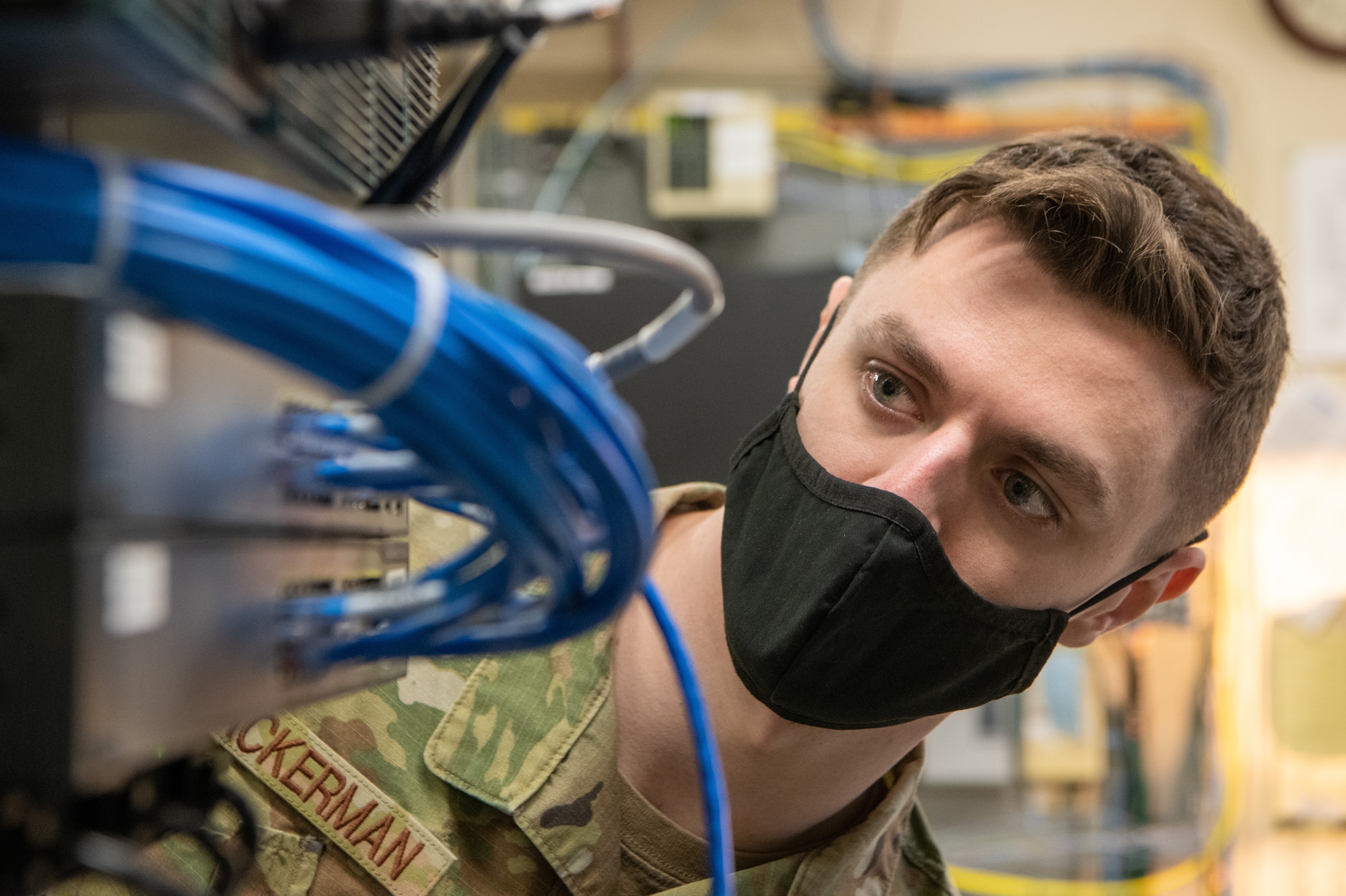 Senior Airman Samuel Ackerman, a 611th Air Communications Squadron Mission Defense Team operator, checks cable connections on the server tower.