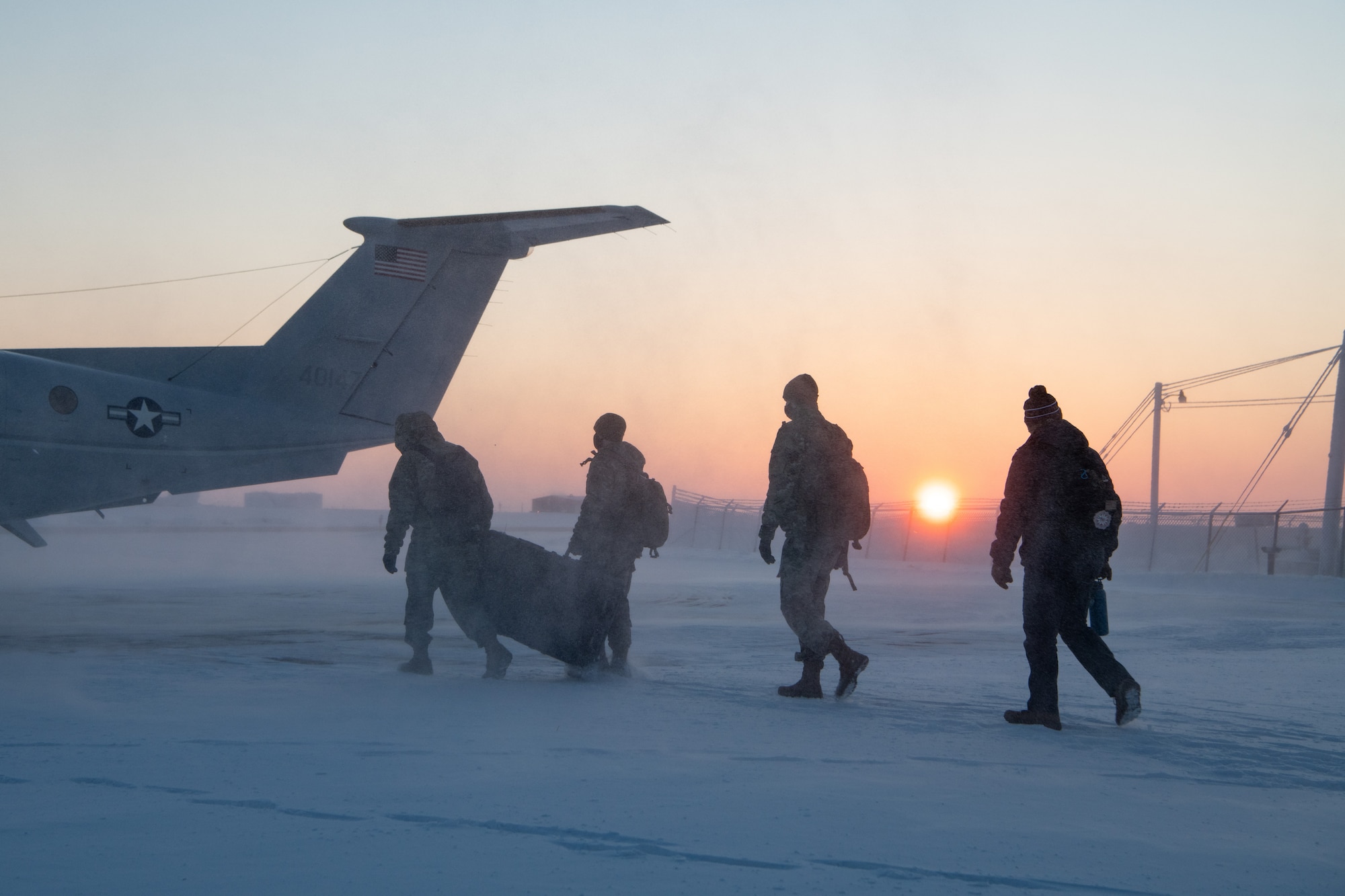 Members of the 611th Air Communications Squadron Mission Defense Team return to a U.S. Air Force C-12 Huron after completing their mission.