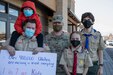 A soldier poses for a photo with three boy scouts