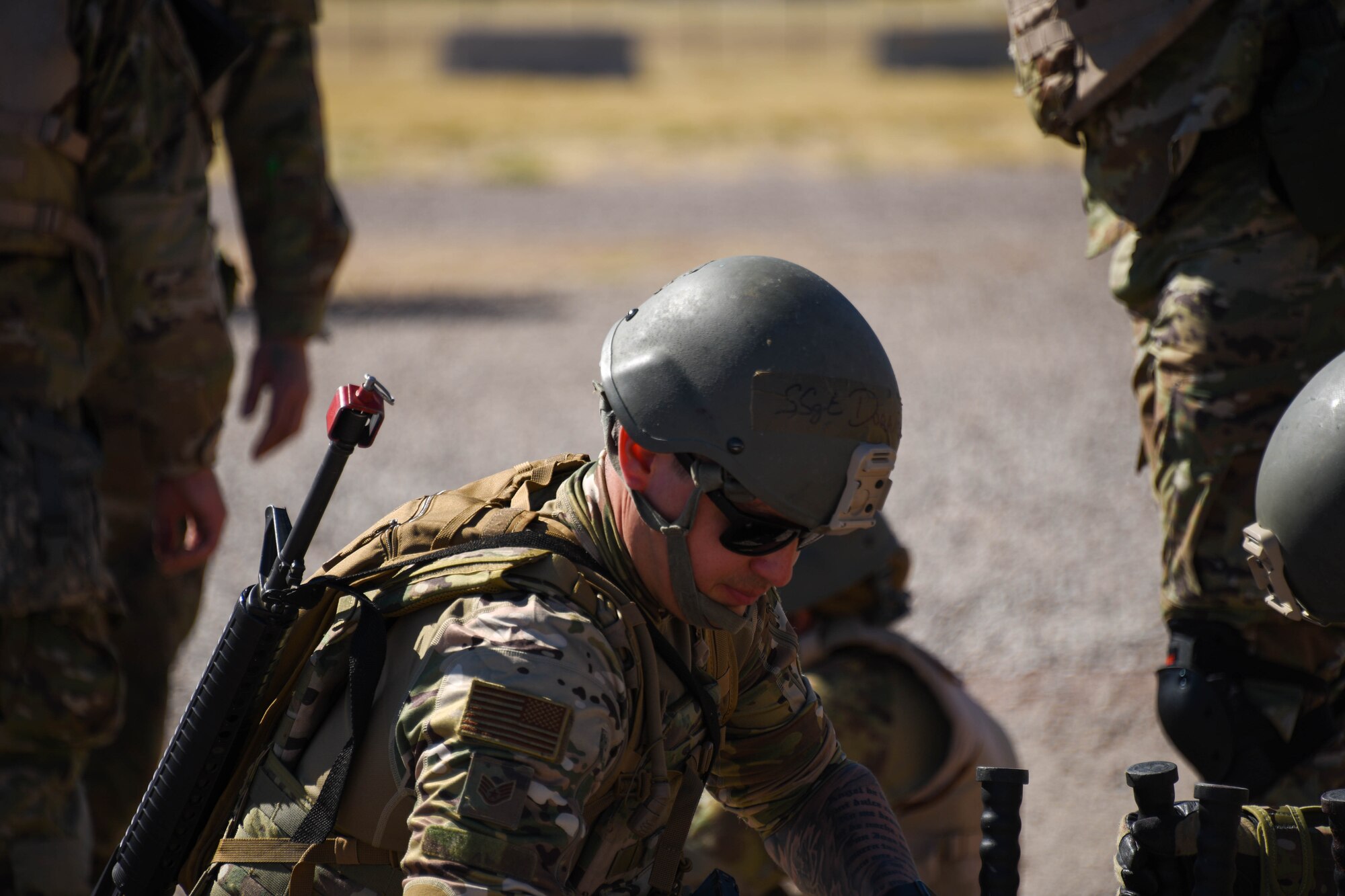 A photo of an Airman inspecting his gear while at an entry control point.