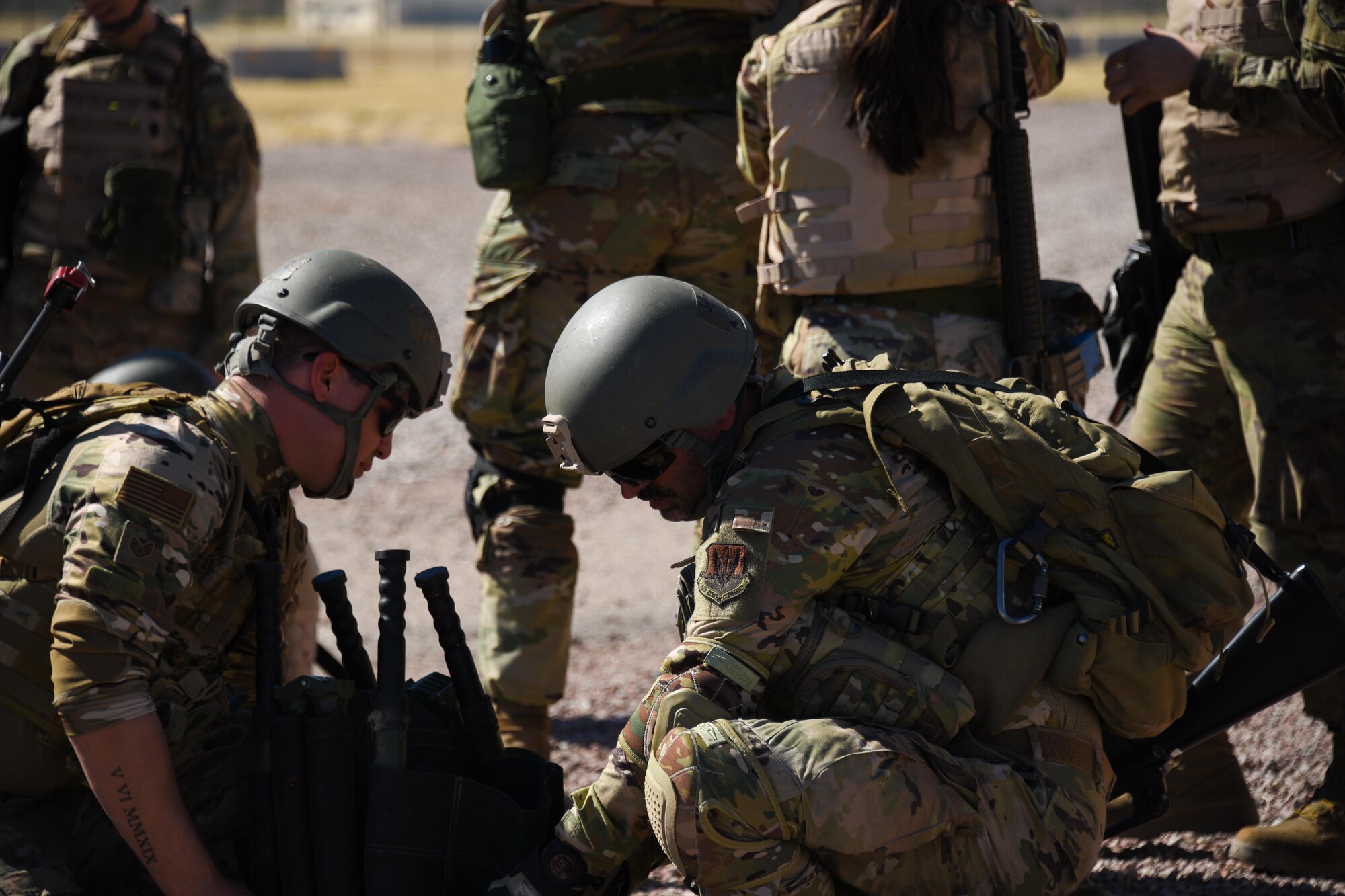 A photo of Airmen checking for injuries on a simulated casualty.