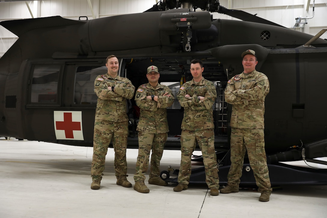 Alaska Army National Guard Chief Warrant Officer 2 Bradley Jorgensen, Sgt. 1st Class Damion Minchaca, Capt. Cody McKinney, and Staff Sgt. Sonny Cooper, all members of Golf Company, 2-211th General Support Aviation Battalion, pose for a photo in front of an HH-60M Black Hawk helicopter at Bryant Army Airfield on Joint Base Elmendorf-Richardson, Feb. 17, 2022. The crew received the DUSTOFF Association 2021 Rescue of the Year award for their efforts in a rescue completed Sept. 15, 2021. DUSTOFF is a nonprofit organization for veterans and service members involved with Army aeromedical evacuation programs. The team will officially be presented the award in San Antonio, Texas, May 21. (U.S. Army National Guard photo by Spc. Grace Nechanicky)
