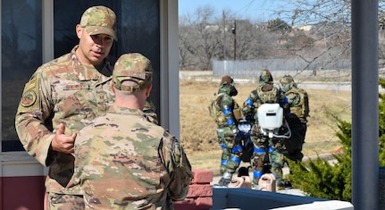 Master Sgt. James Gonzales, 433rd Civil Engineer Squadron explosive ordnance disposal training section supervisor, talks with Master Sgt. Robert Pinkston, 433rd CES EOD program manager, during an exercise at Joint Base San Antonio-Lackland, Texas, Feb. 9, 2022. Both Gonzales and Pinkston evaluated EOD technicians during their training tasks. (U.S. Air Force photo by Airman Mark Colmenares)