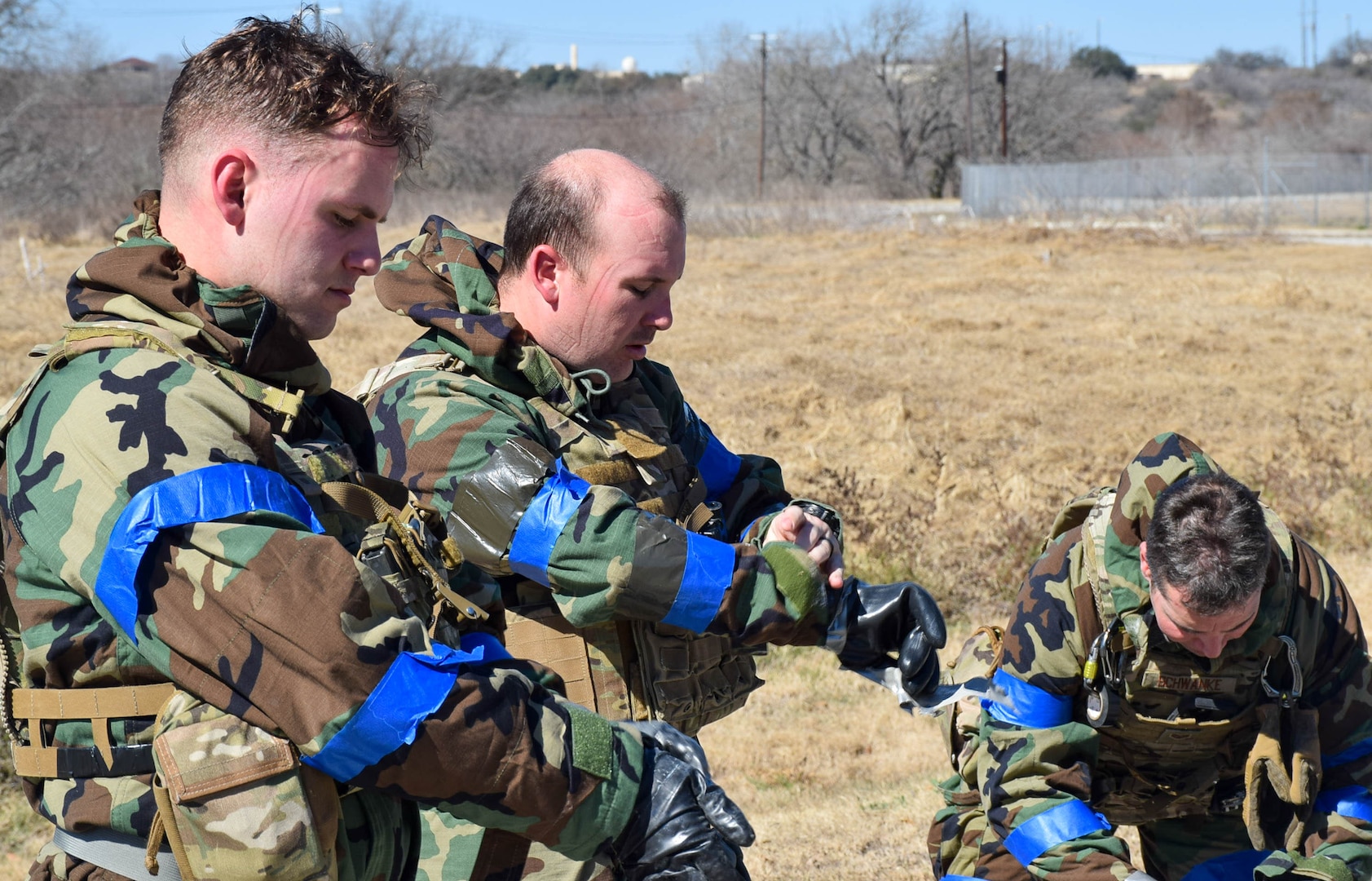 Explosive ordnance disposal technicians from the 433rd Civil Engineer Squadron, (left to right) Staff Sgt. Kendall Greer, Tech. Sgt. Brian Cole and Staff Sgt. David Schwanke, remove chemical protection gear during an exercise at Joint Base San Antonio-Lackland, Texas, Feb 9, 2022. (U.S. Air Force photo by Airman Mark Colmenares)