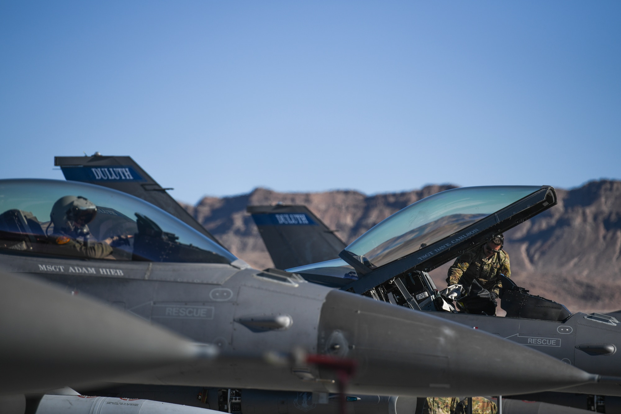 A U.S. Air Force F-16 Crew Chief assigned to the 148th Fighter Wing, Minnesota Air National Guard, Duluth, Minn., pulls the cockpit cover off prior to a flight at Nellis Air Force Base, Nev., Feb 8, 2022, while participating in Red Flag 22-1.