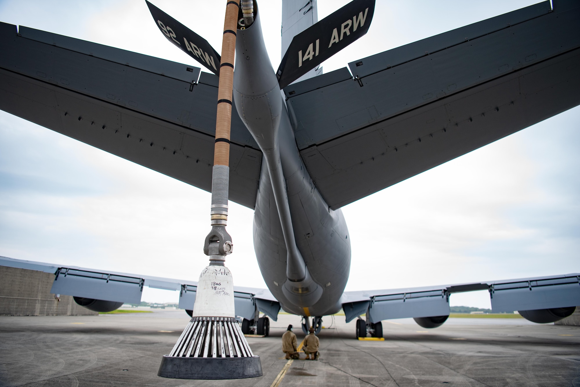 Two Airmen perform pre flight checks on an aircraft.