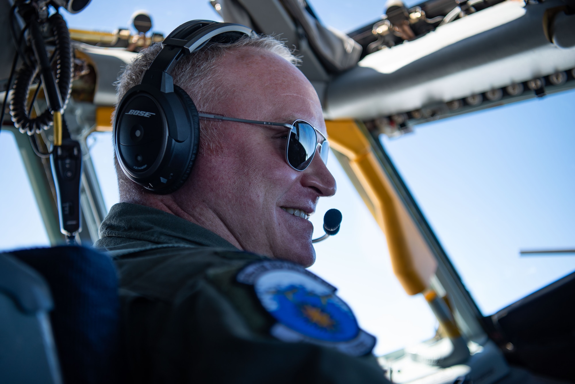 A pilot smiles while navigating a plane.