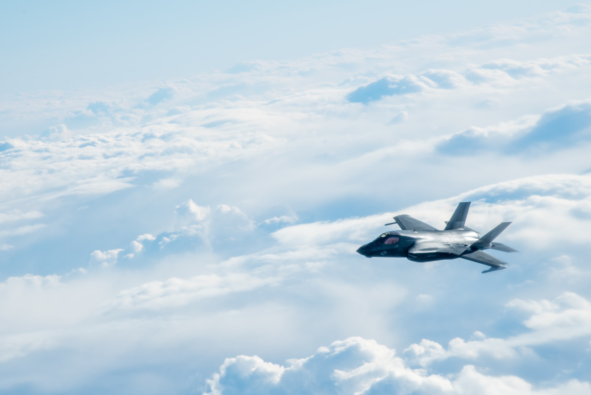 A jet flies above the clouds.