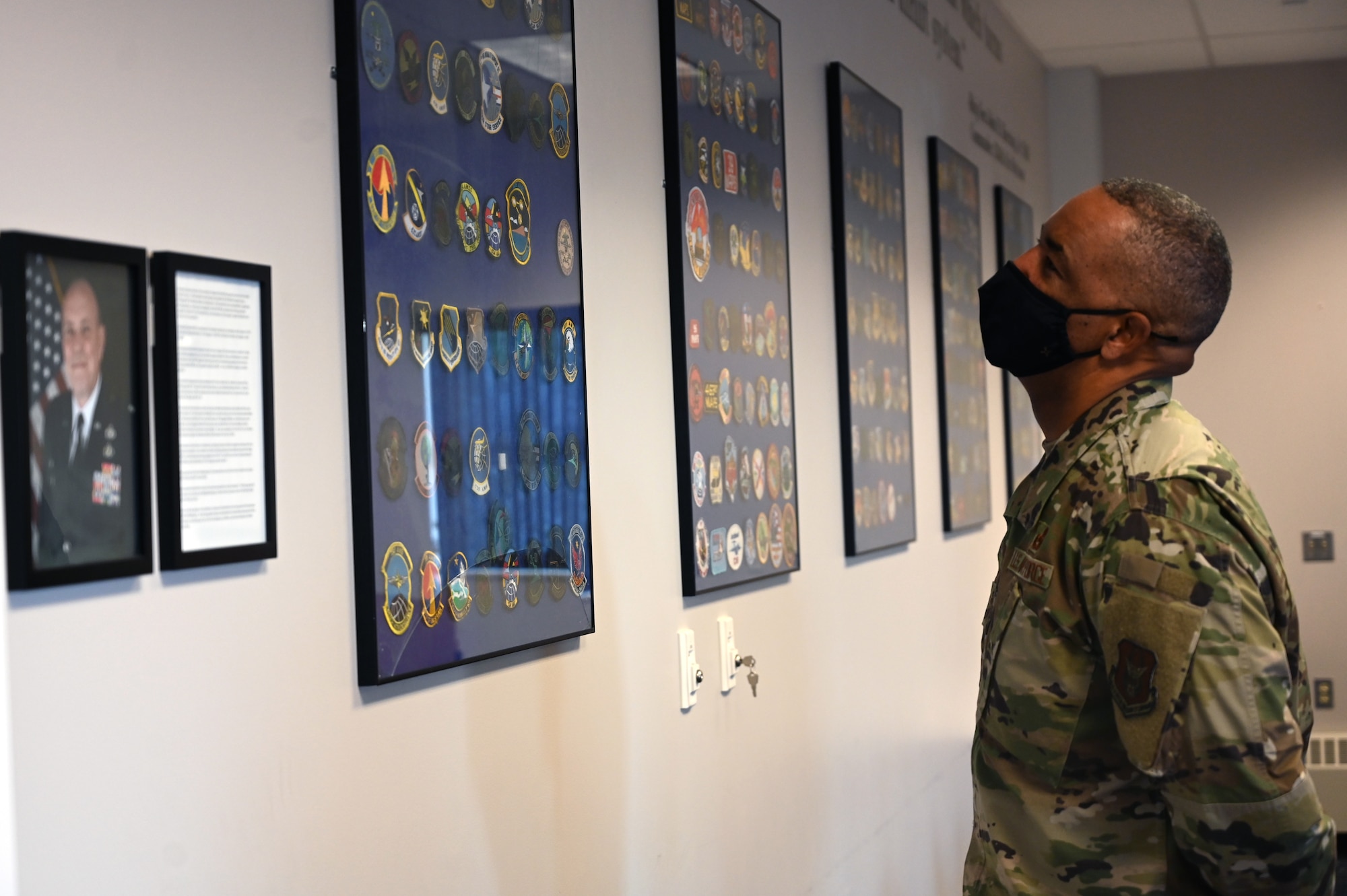Chief Master Sgt. Timothy C. White, the Air Force Reserve Command Chief, looks at the wall of historical patches in the 32nd Aerial Port Squadron at the Pittsburgh International Airport Air Reserve Station, Pennsylvania, Jan. 8, 2022.