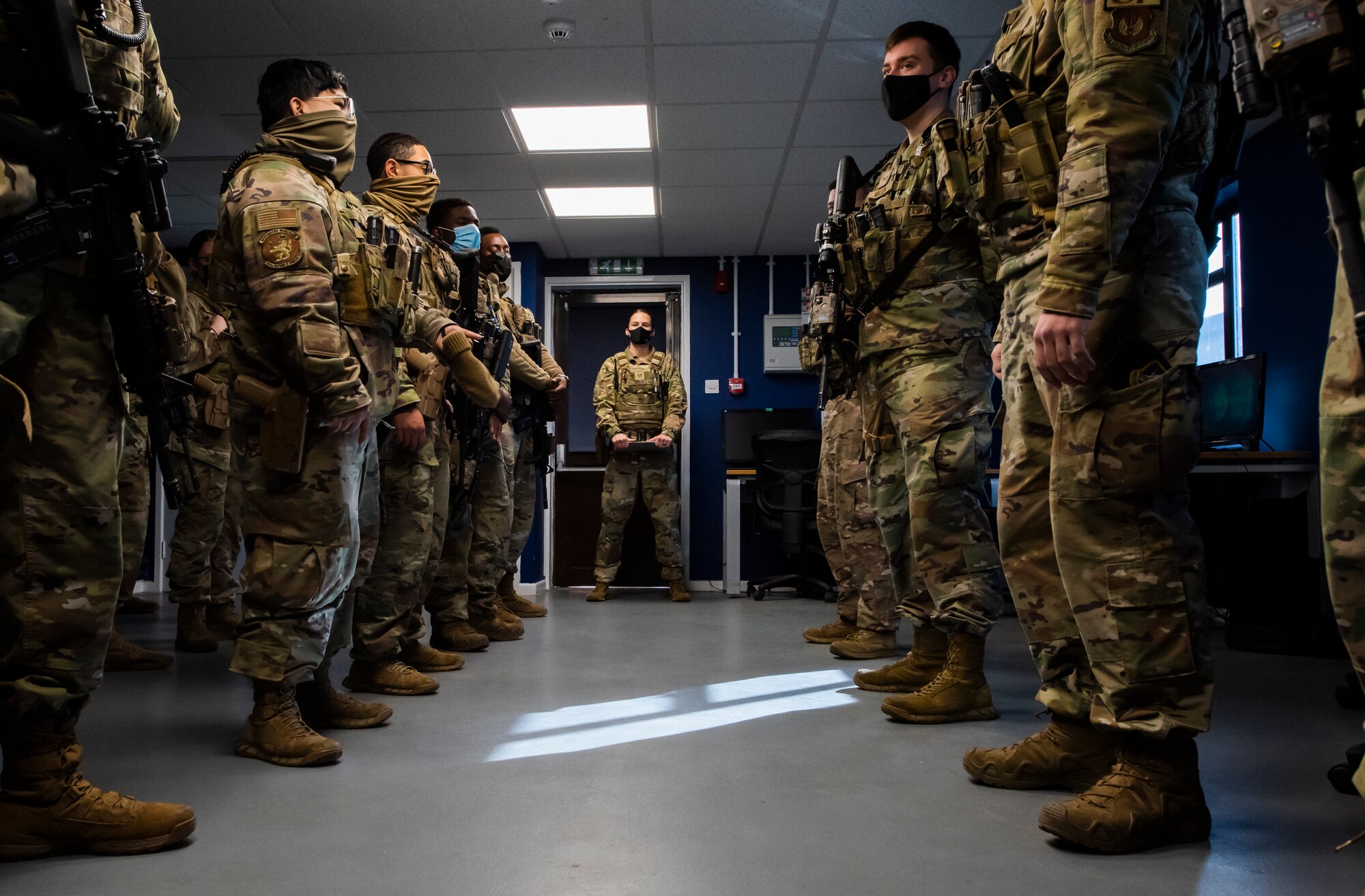 U.S. Air Force Tech. Sgt. Rachel Newell, 100th Security Forces Squadron flight sergeant, watches members of the 100th SFS Charlie flight during guard mount at Royal Air Force Mildenhall, England, Feb. 17, 2022. Guard mount is performed at the start of each shift change and Airmen are briefed on everything they need to know to start the day. (U.S. Air Force photo by Senior Airman Kevin Long)