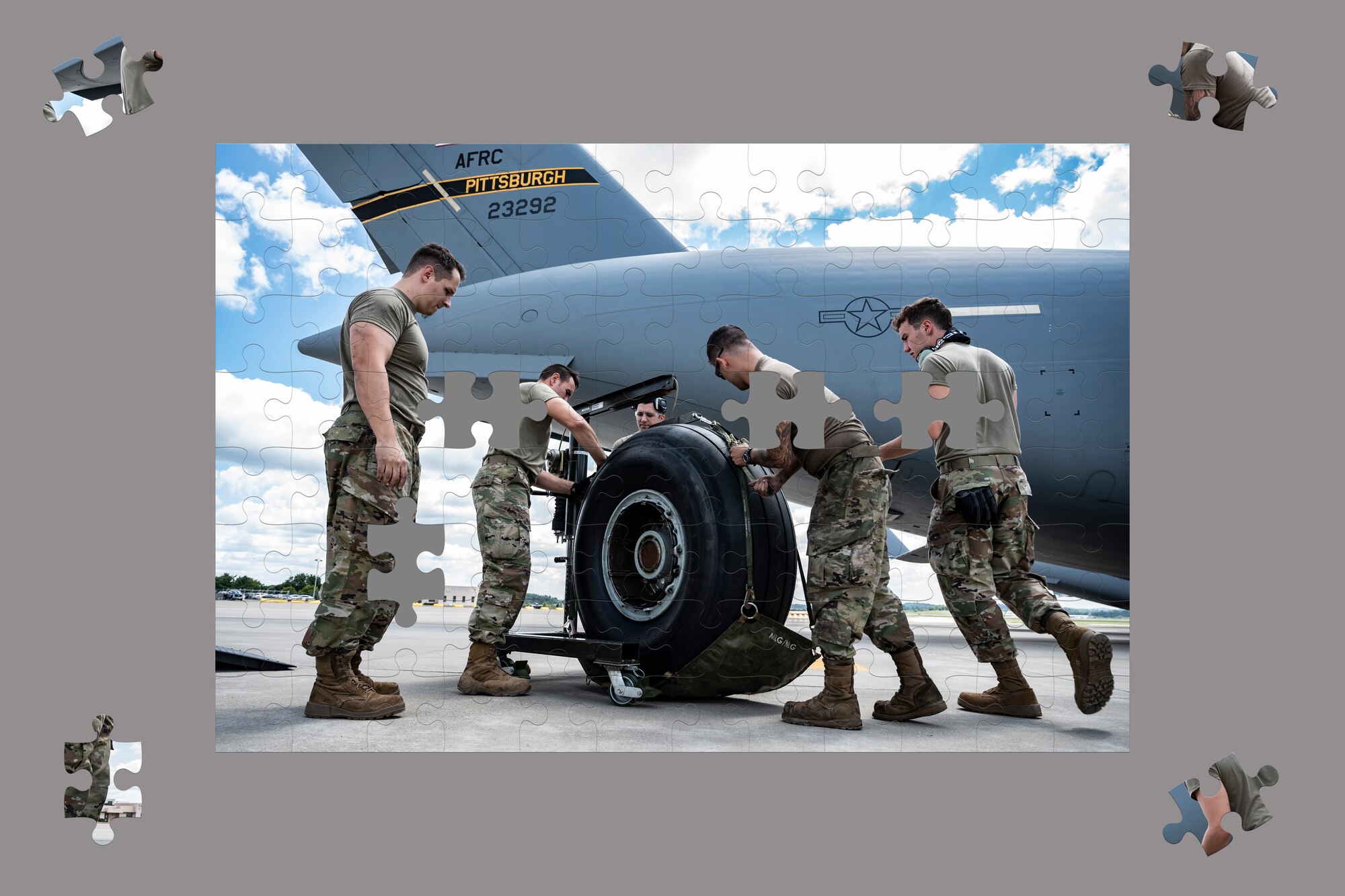 Airmen assigned to the 911th Maintenance Group load a C-17 Globemaster III tire onto a harness during a tire change at the Pittsburgh International Airport Air Reserve Station, Pennsylvania, Aug. 2, 2021.