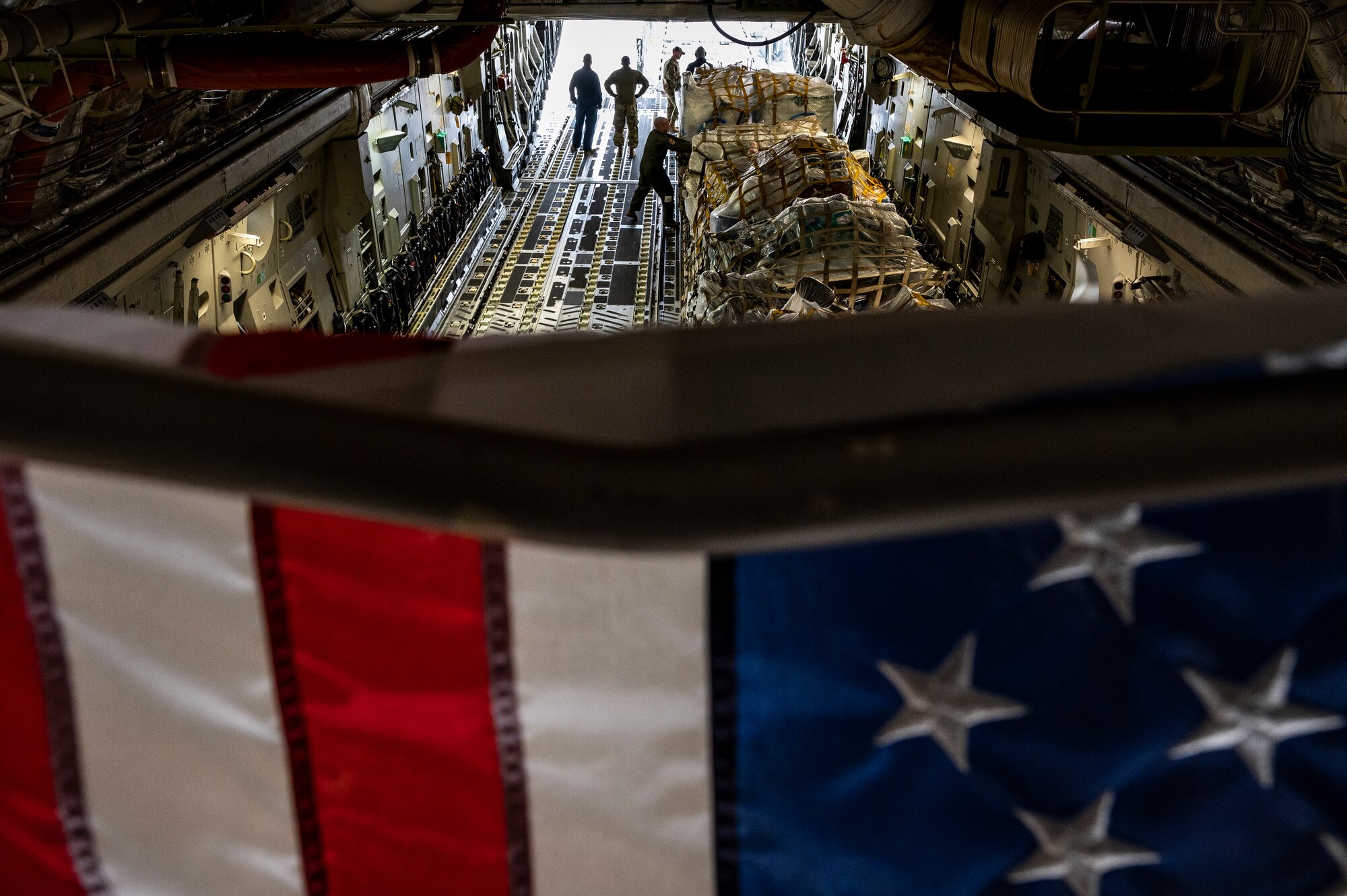 Airmen assigned to the 911th Airlift Wing load cargo for the Department of Defense's Denton Program onto a C-17 Globemaster III at the Pittsburgh International Airport Air Reserve Station, Pennsylvania, Feb. 16, 2022.