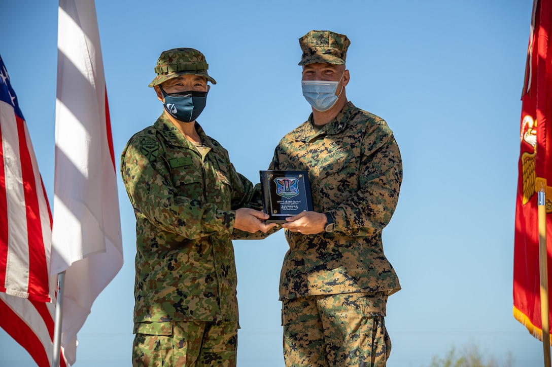 Japan Ground Self-Defense Force (JGSDF) Col. Kazuhiro Irie, commanding officer of the 2nd Amphibious Rapid Deployment Regiment, left, gifts a plaque in honor of exercise Iron Fist 2022 to U.S. Marine Corps Col. Sean Dynan, commanding officer of the 15th Marine Expeditionary Unit during the closing ceremony at Marine Corps Base Camp Pendleton, California, Feb. 16, 2022. For almost two decades the U.S. Marine Corps, U.S. Navy, and JGSDF have conducted exercise Iron Fist, training together in amphibious operations and affirming the U.S. commitment to our allies. (U.S. Marine Corps photo by Cpl. Aidan Hekker)