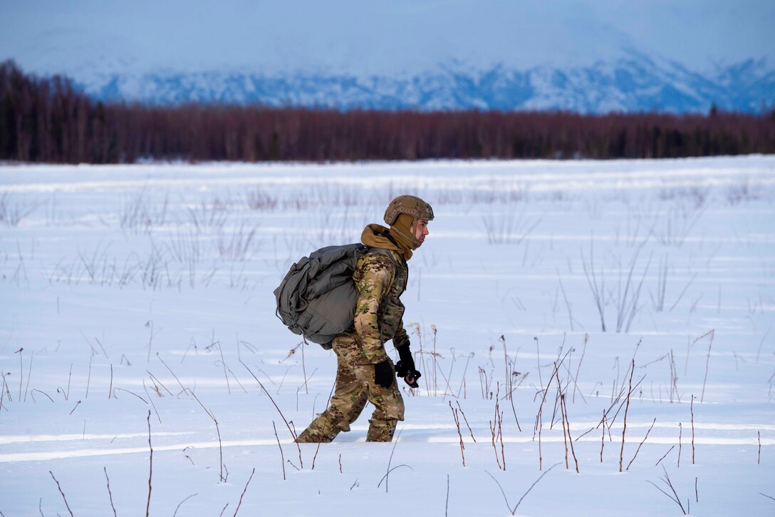 An airman walks through snow.