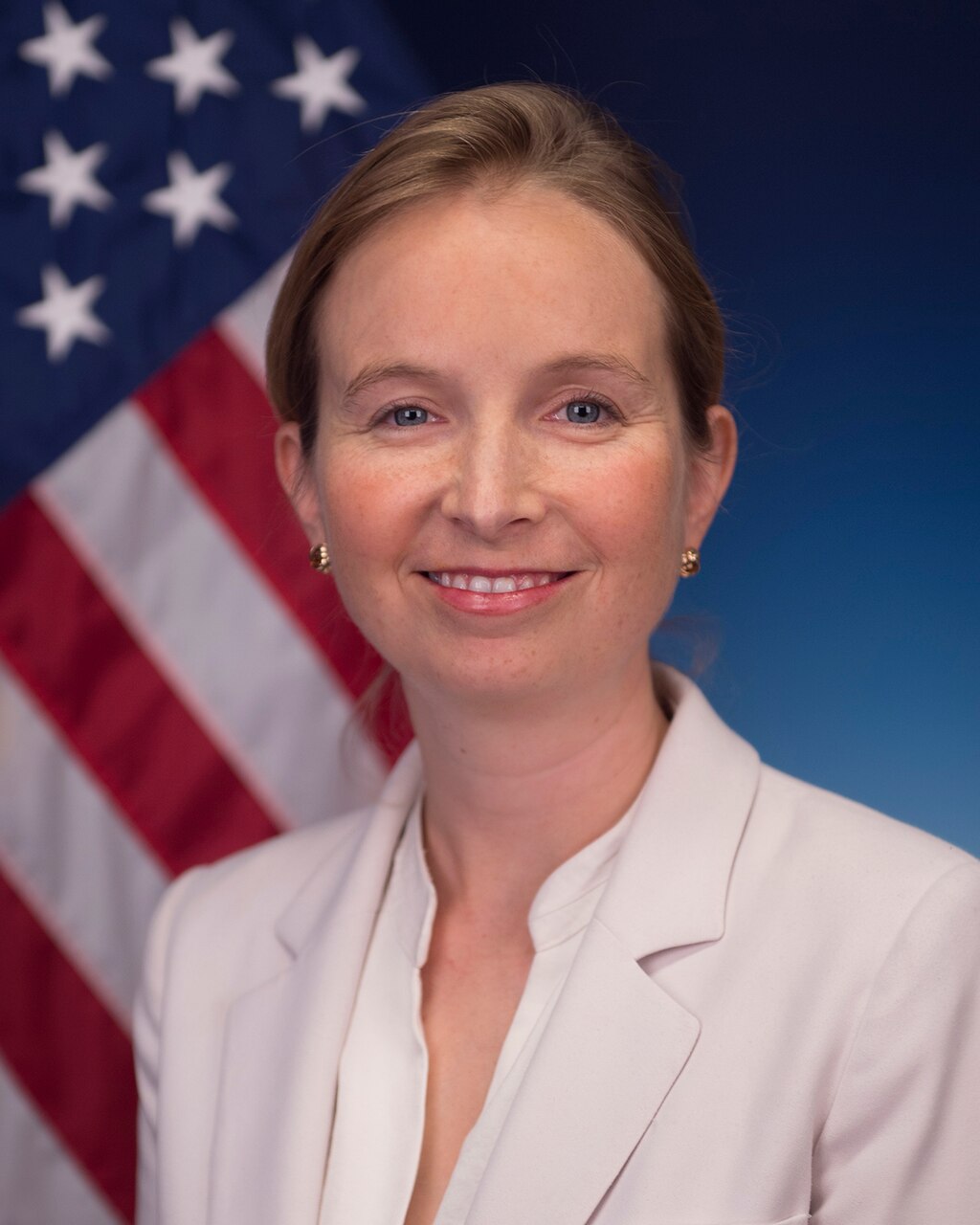 A woman poses in front of a flag.