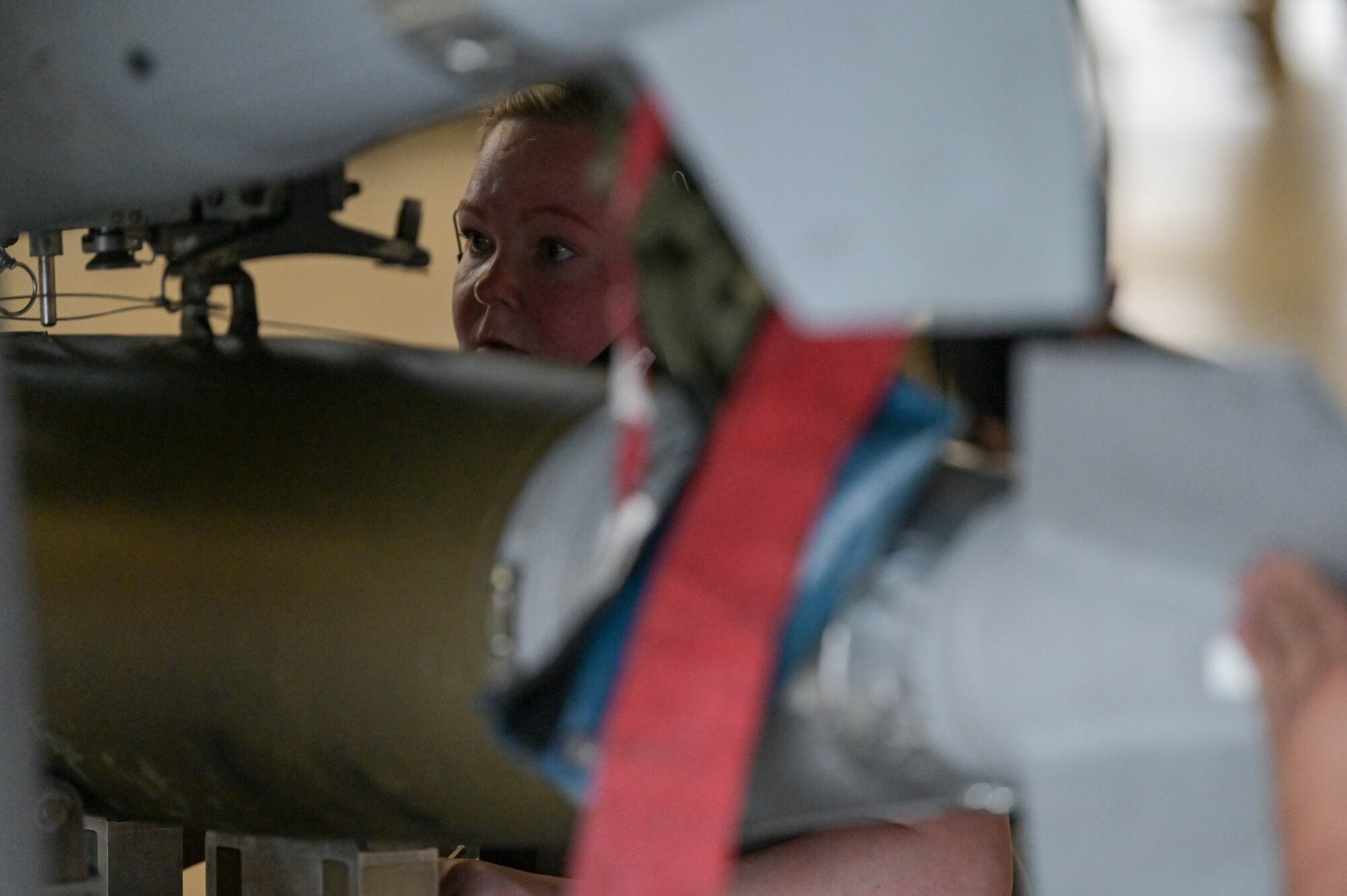 U.S. Air Force Staff Sgt. Brianna Stone. 476th Maintenance Squadron load crew team chief, installs a training weapon at Moody Air Force Base, Georgia, Feb. 4, 2022. Proficiency is crucial to safely loading weapons on any aircraft, demonstrating mission readiness and lethality. (U.S. Air Force photo by Senior Airman Rebeckah Medeiros)