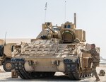 A U.S. Soldier from the 2nd Platoon, Alpha Company, 1/163rd Combined Arms Battalion, inspects a Bradley M2A3 Fighting Vehicle at Ali Al Salem AB, Jan. 27, 2022. The vehicle is a light armored, fully tracked transport vehicle, providing cross-country mobility with mounted firepower and protection from artillery and small-arms fire. (U.S. Air National Guard photo by Staff Sgt. Chloe Ochs)