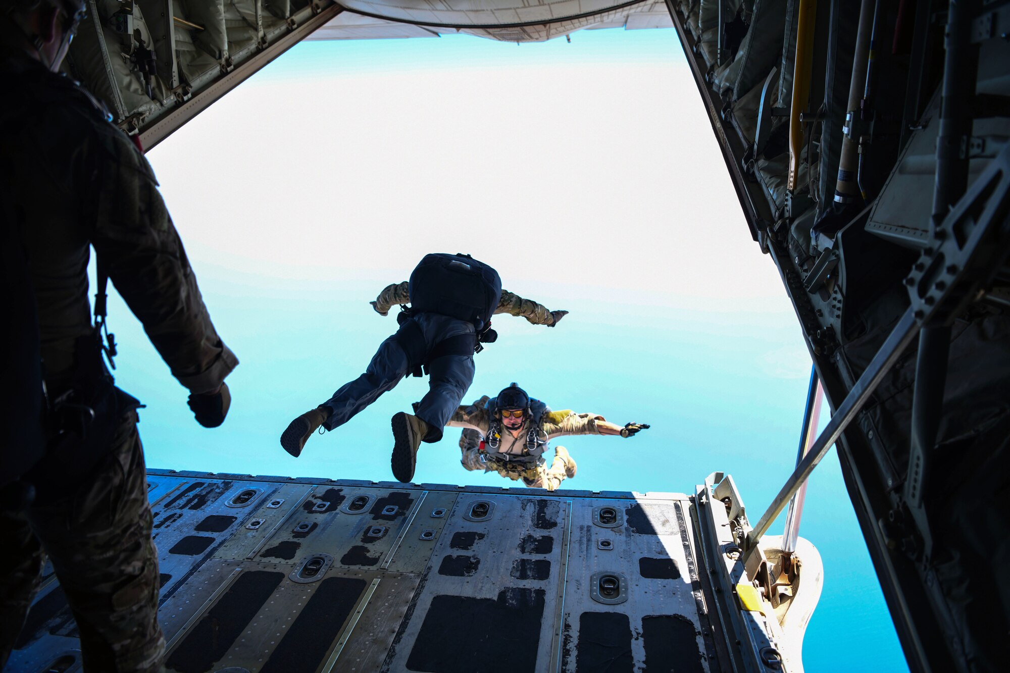 Two U.S. Air Force pararescuemen assigned to the 82nd Expeditionary Rescue Squadron jump from a U.S. Marine Corps KC-130J Super Hercules