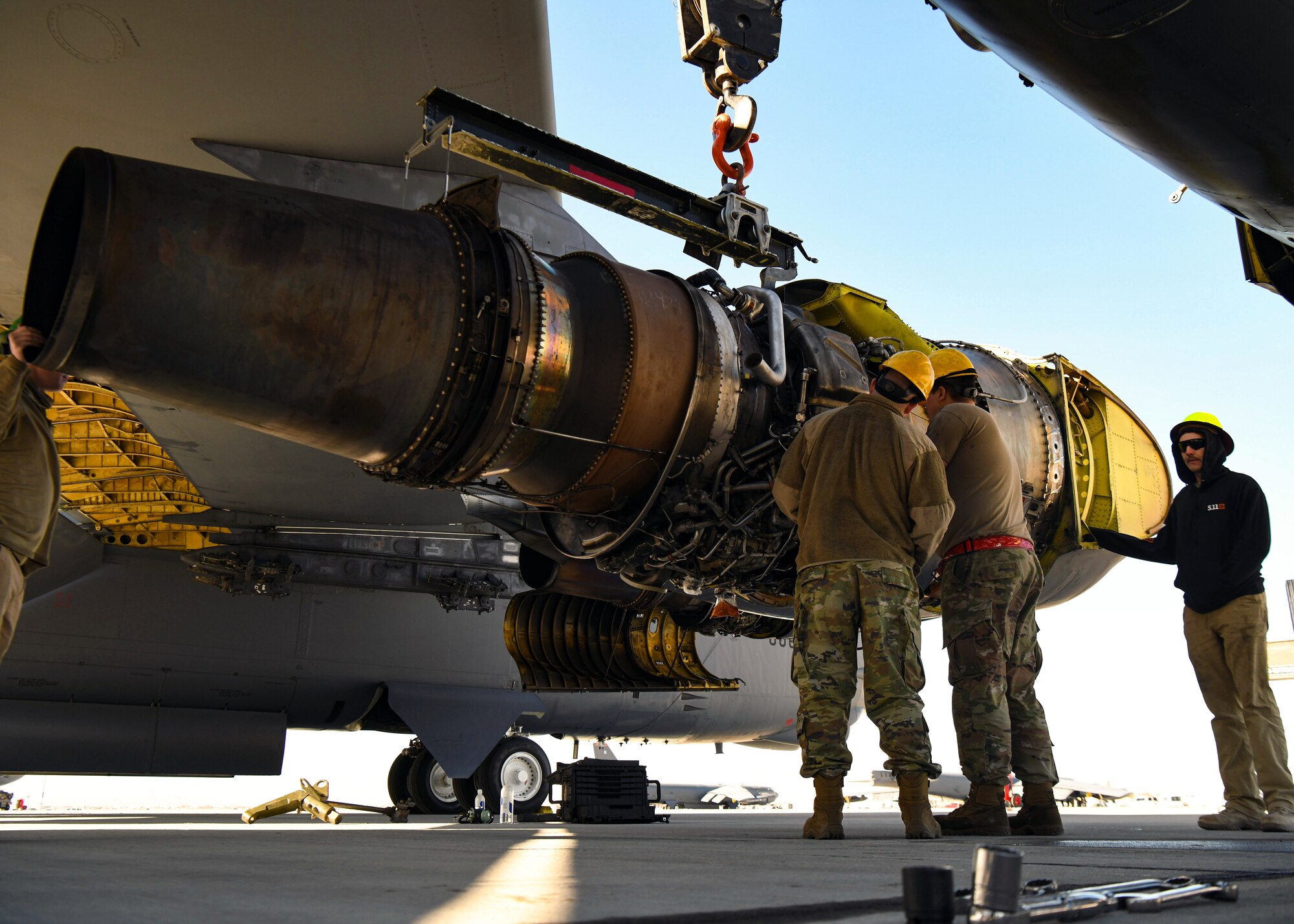 Airmen with the 5th Maintenance Squadron and the 99th Civil Engineering Squadron work together to replace a B-52H Stratofortress engine