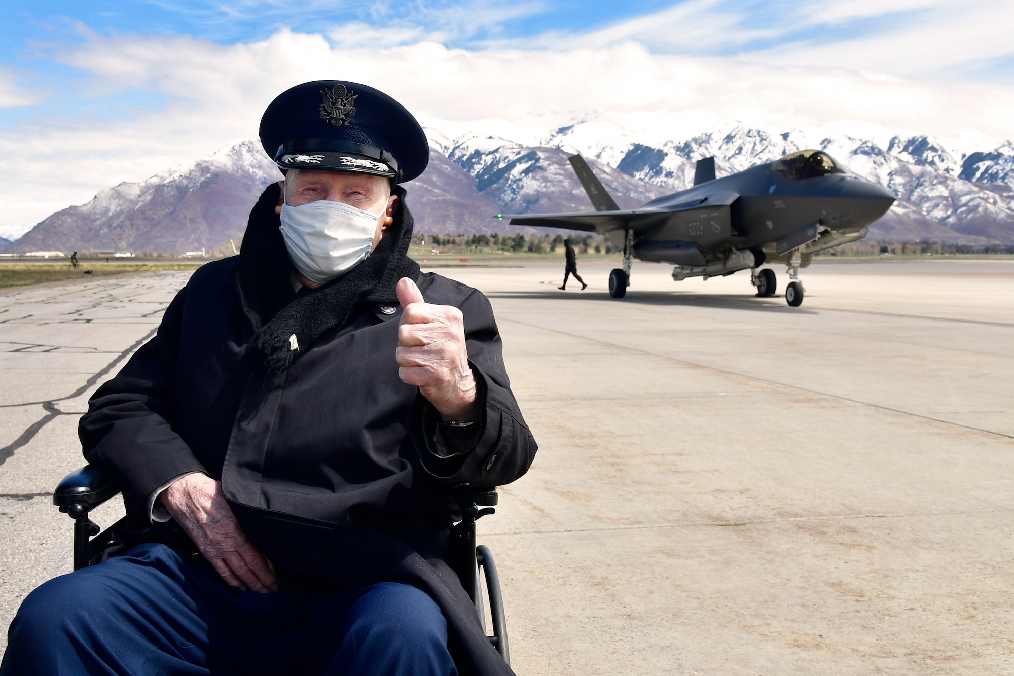 Gail Halvorsen give a thumbs up posing in front of an F-35A Lightning II on the Hill AFB flight line.
