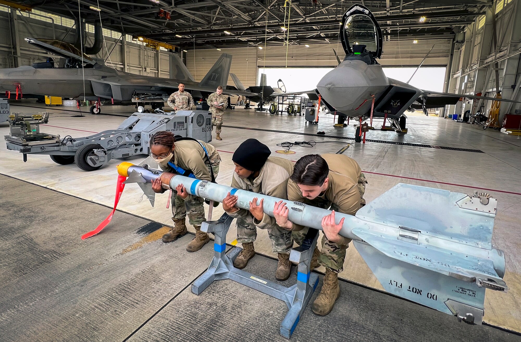 A 43rd Fighter Generation Squadron team lifts an AIM-9 Sidewinder