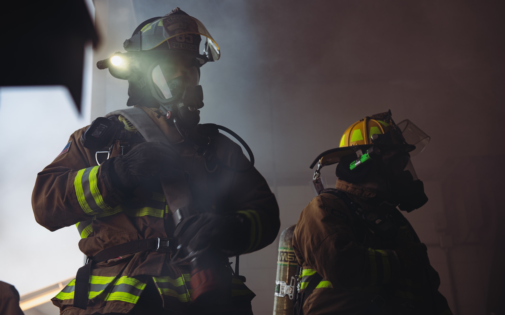 Firefighters enter smoke filled building.