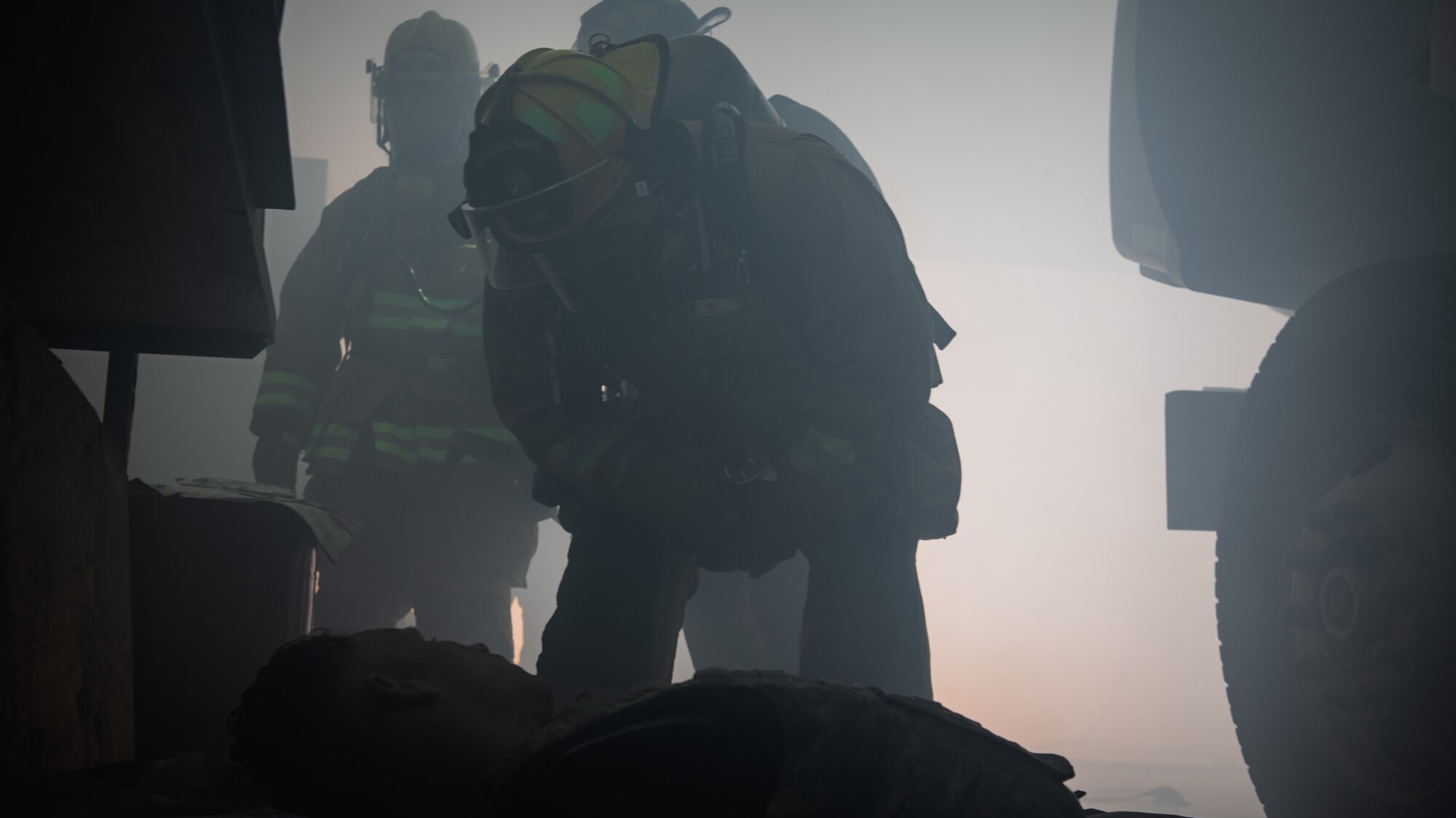 Firefighter checks on an acting dead Airmen.
