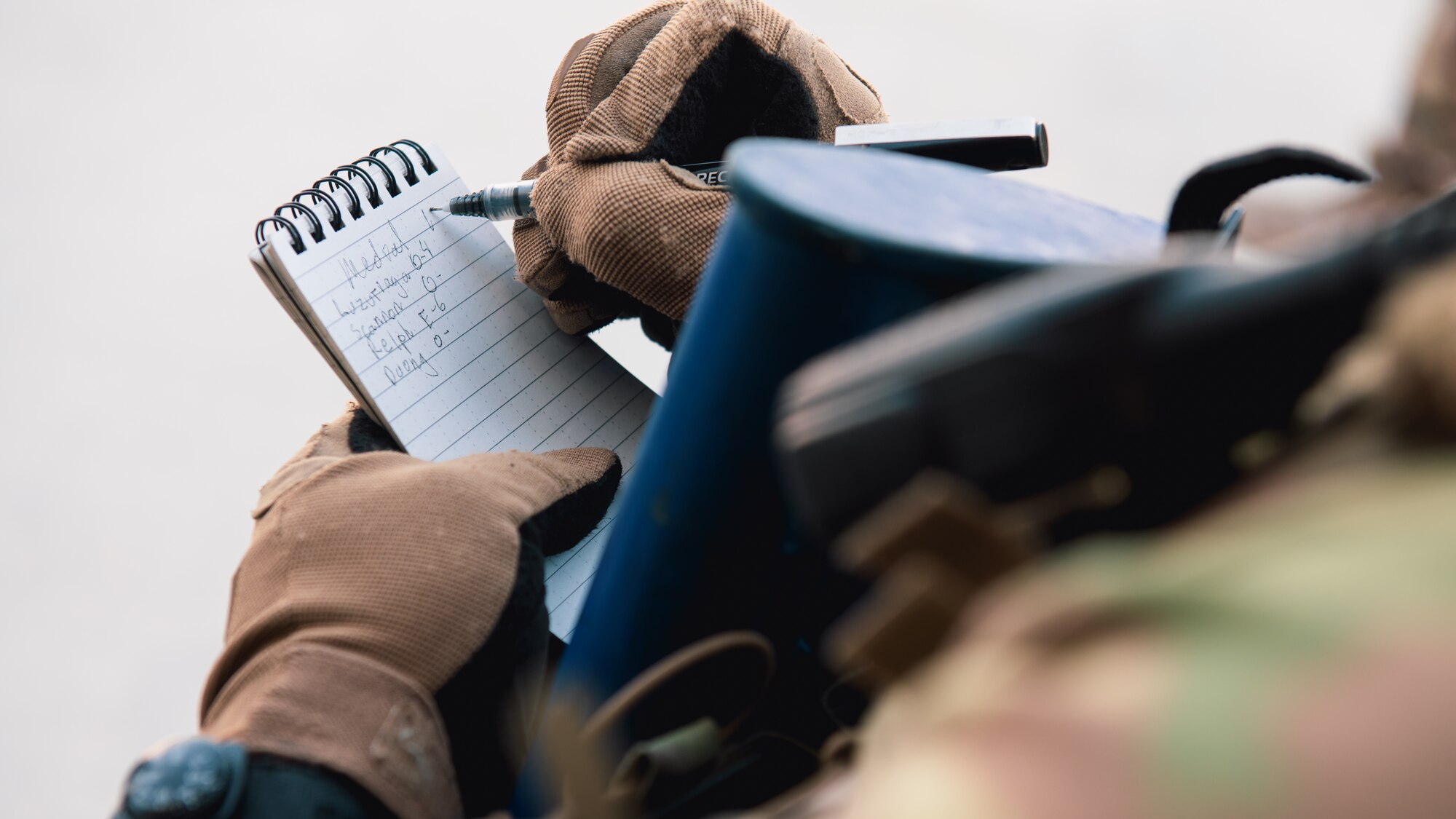 Airman writes notes on a notepad.