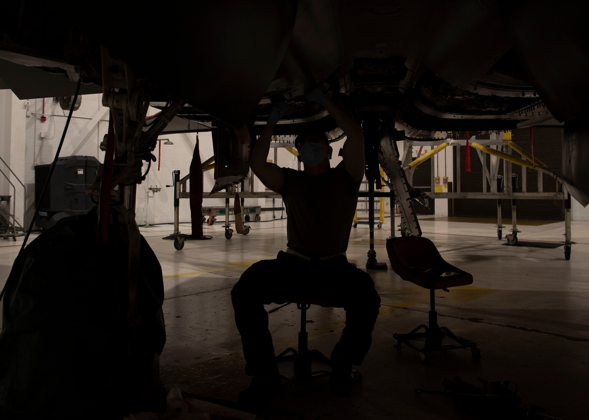 Airman 1st  Class Jobe Bertrand, 4th Equipment Maintenance Squadron crew chief, works under an F-15E Strike Eagle at Seymour Johnson Air Force Base, North Carolina, Jan. 7, 2022.