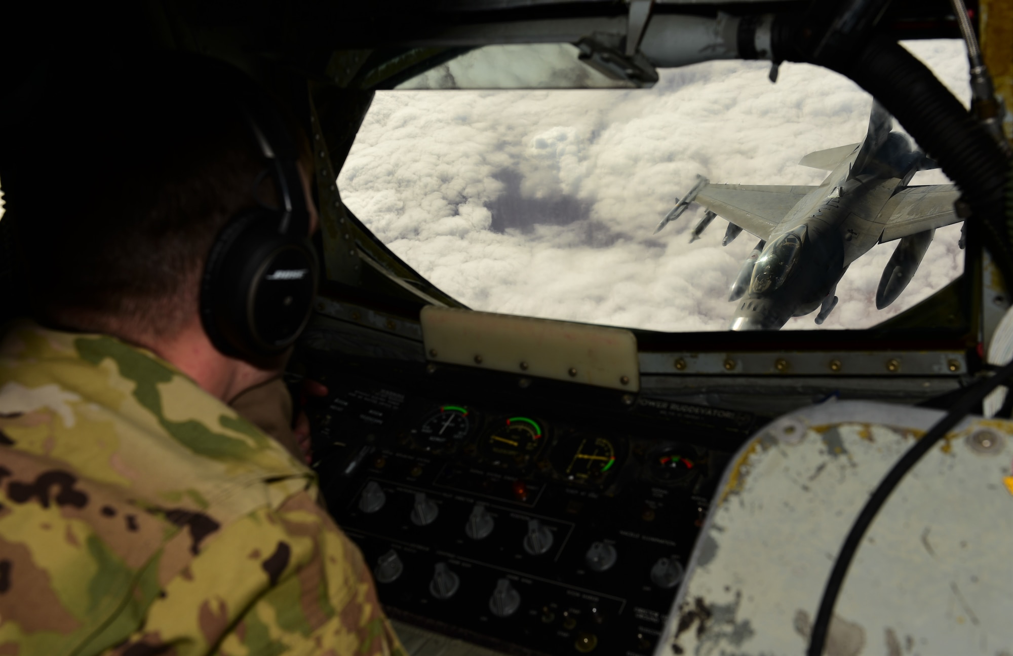 a boom operator prepares to refuel an F-16