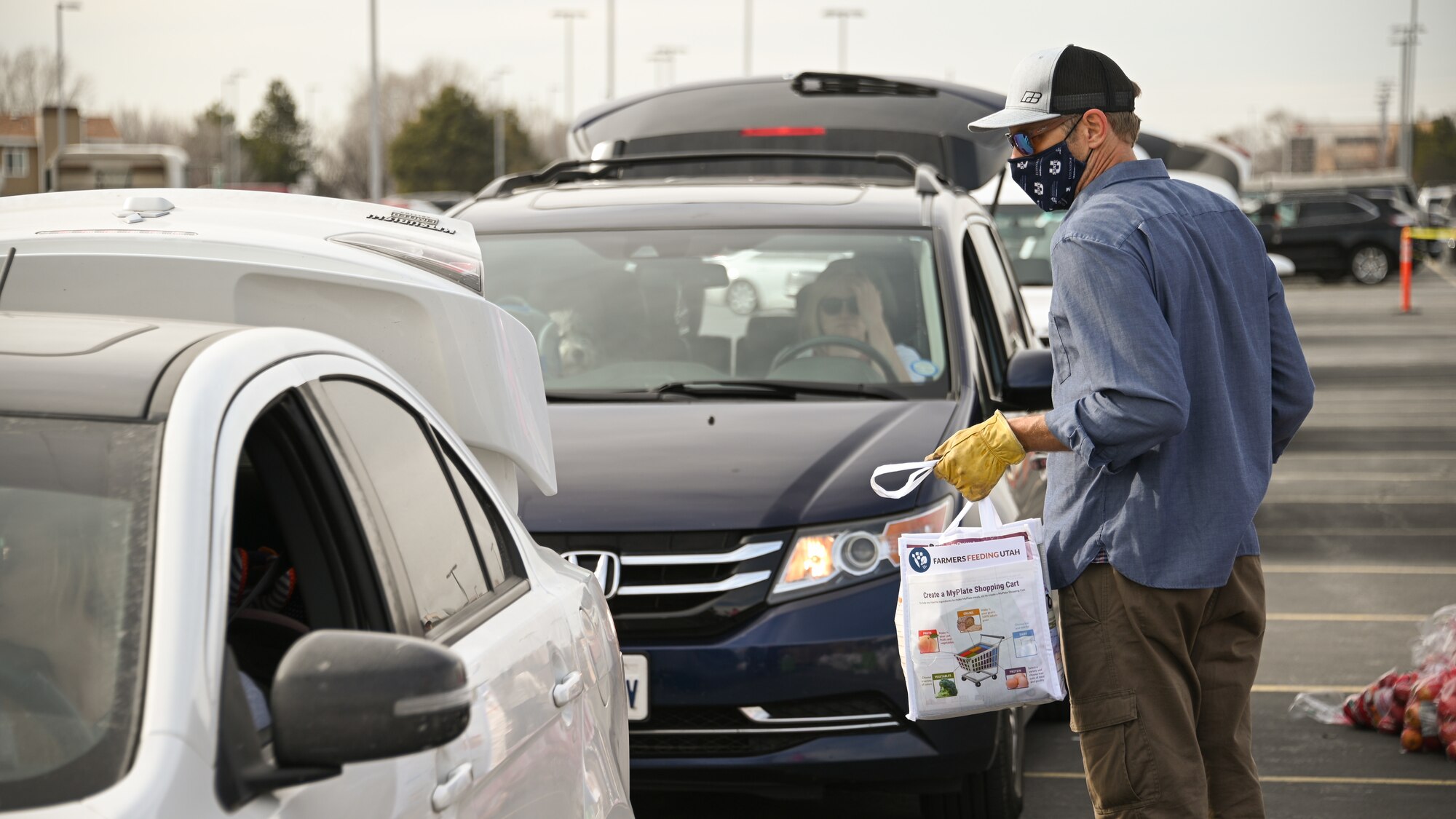 Volunteers load food items into vehicles.