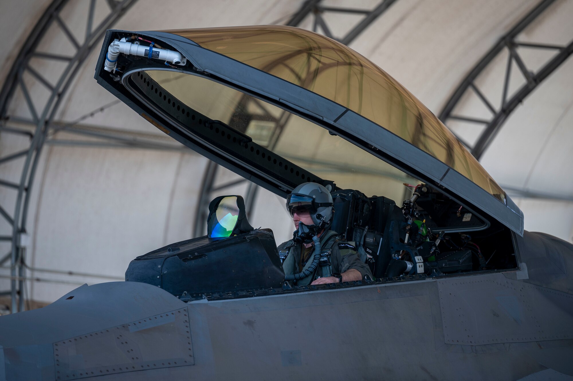 A pilot sit's in the cockpit of an F-22 Raptor